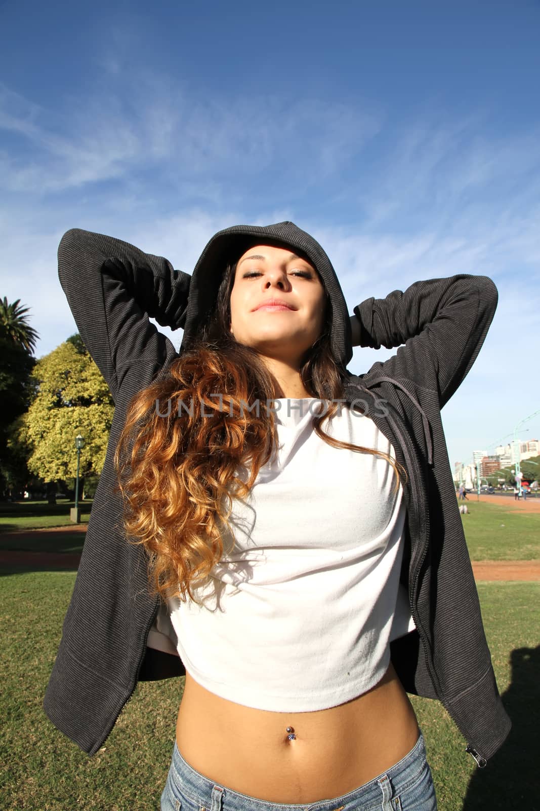 A young woman enjoying the sunlight in the Park.			