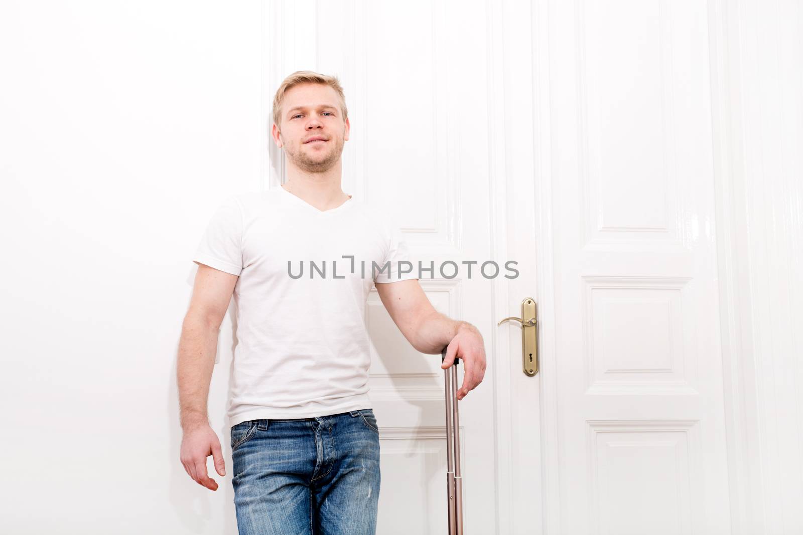 A young man going to travel with a suitcase.