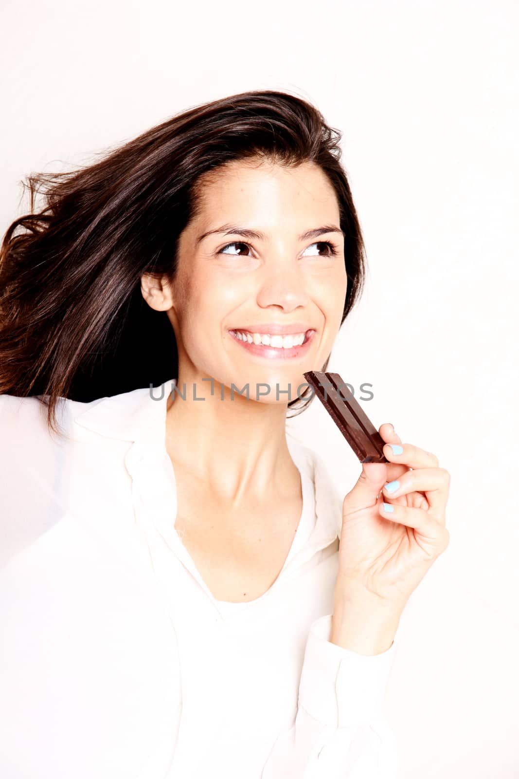 Portrait of a beautiful, latin Woman eating chocolate.