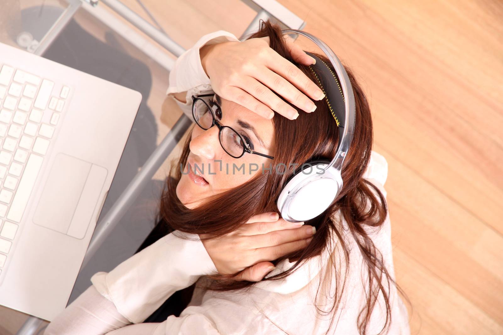 Business woman working on a Laptop while listening music with Headphones.