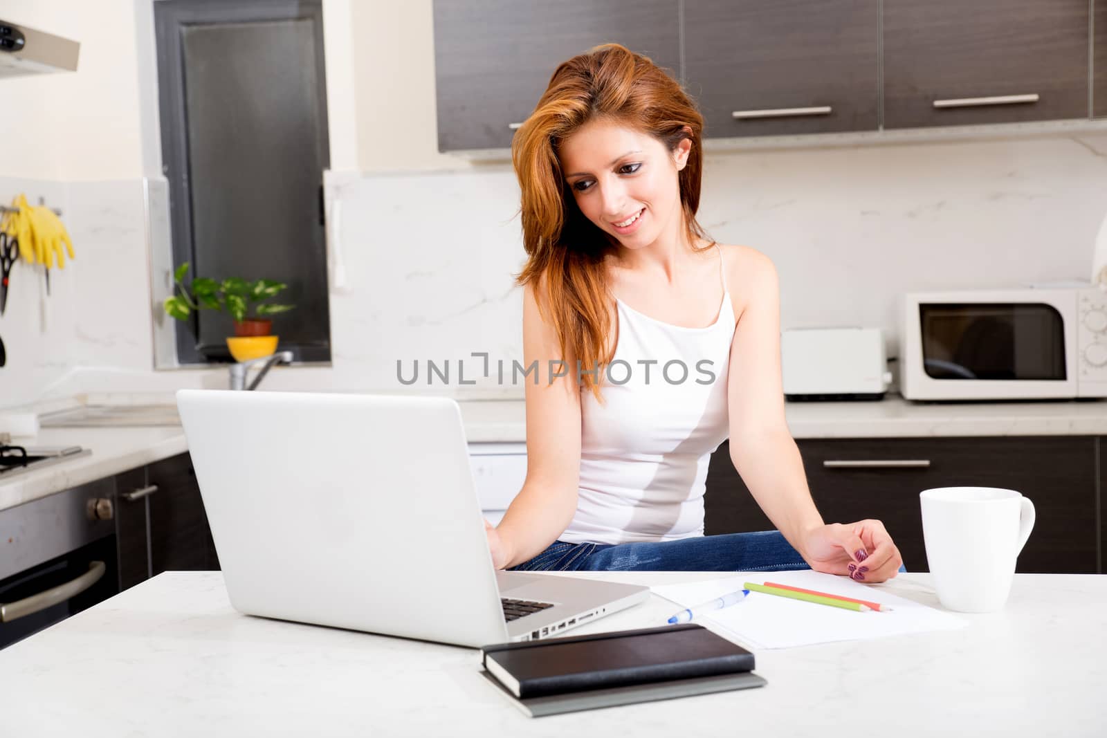 Portrait of a brunette girl working in the kitchen.