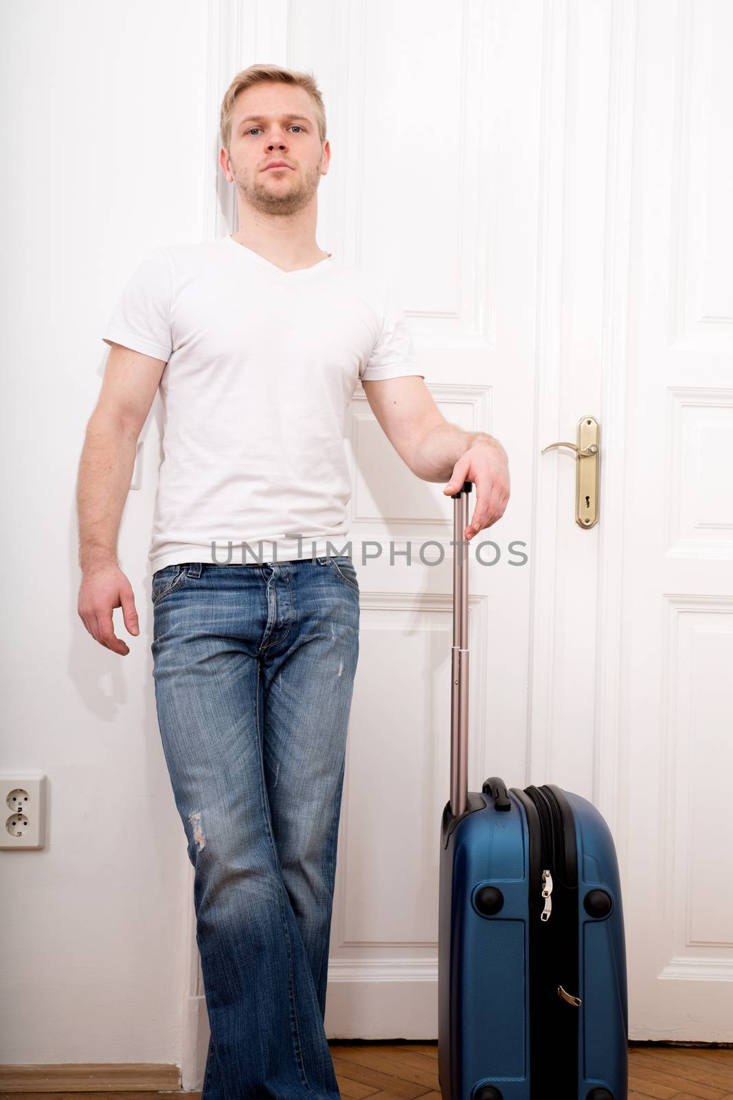 A young man going to travel with a suitcase.