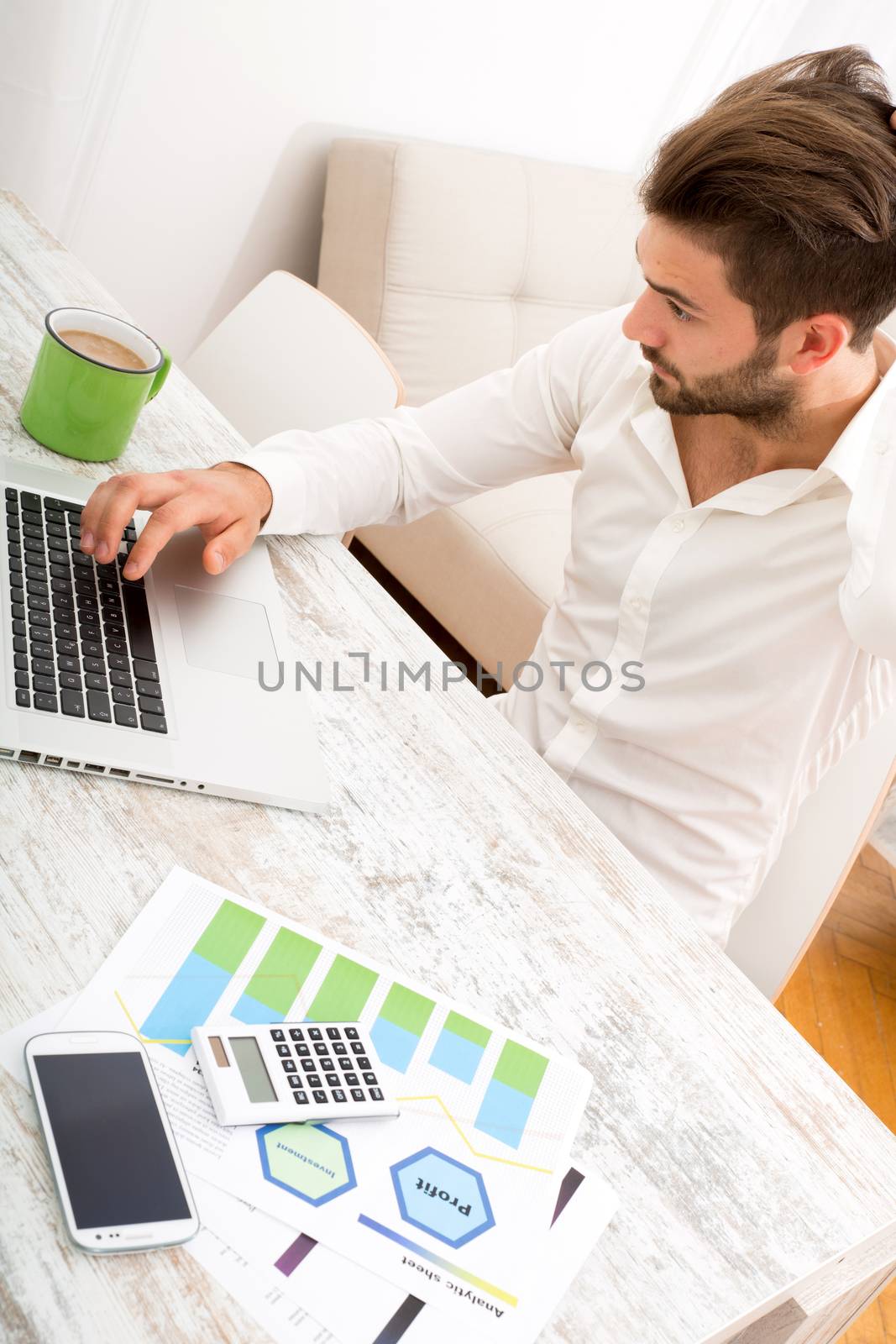 A young man checking his business statistics at home