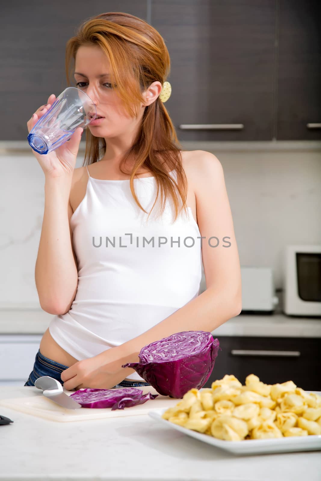 Redhead girl drinking in kitchen by Spectral