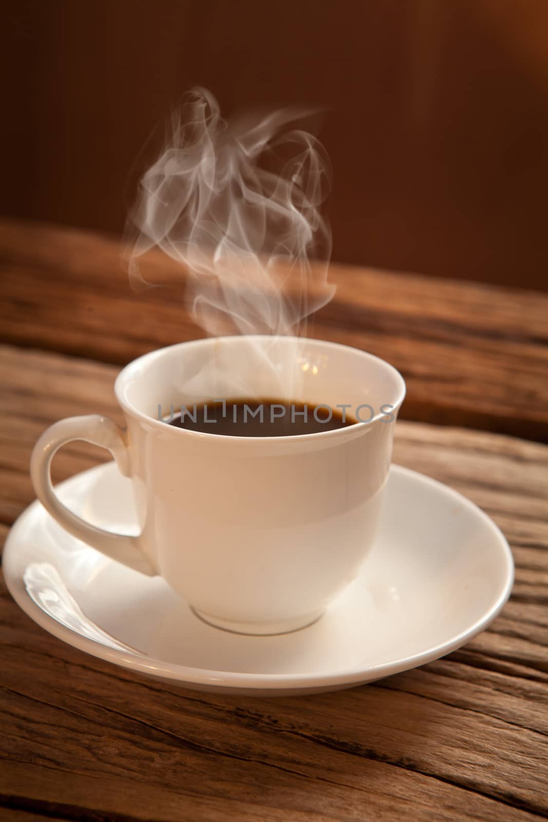 White cup of hot coffee on wood background