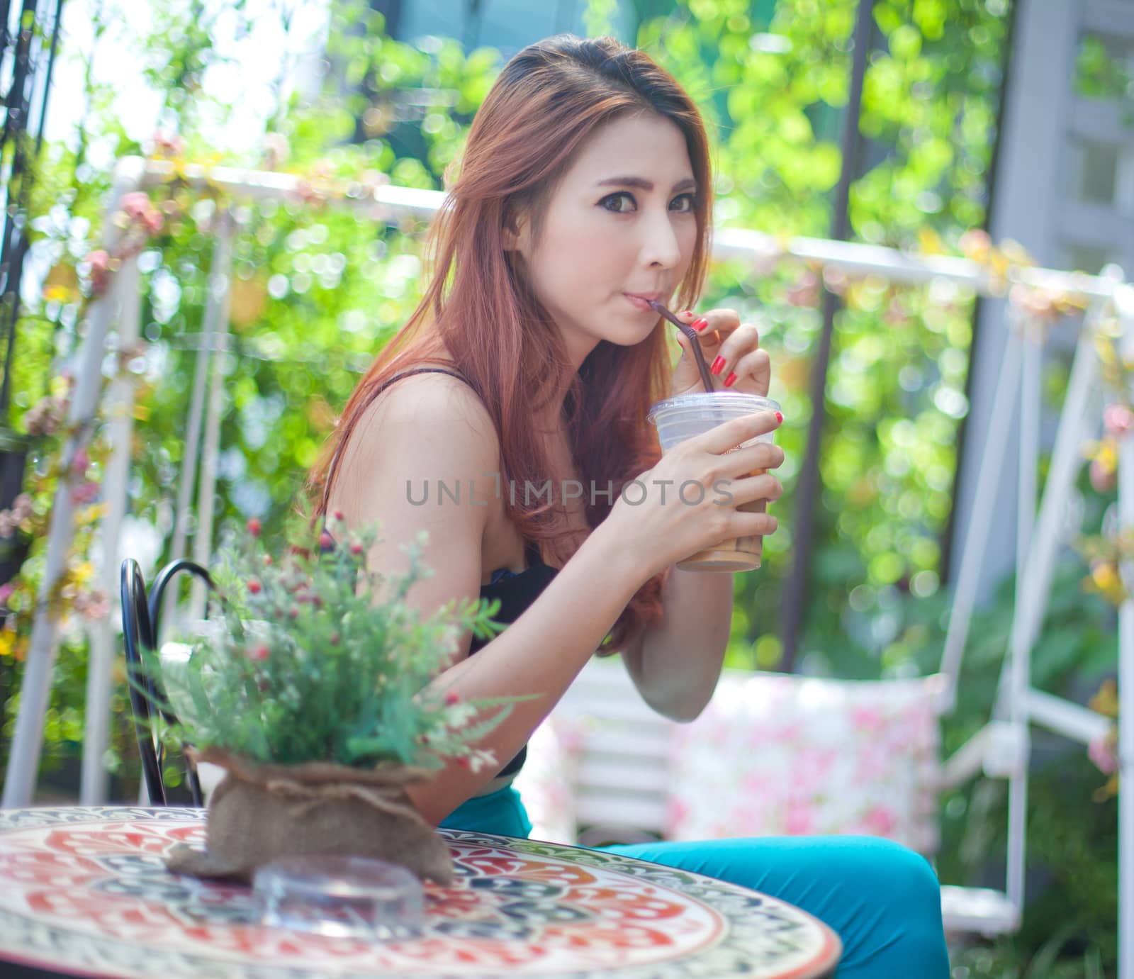 Young asian woman drinking ice coffee at restaurant