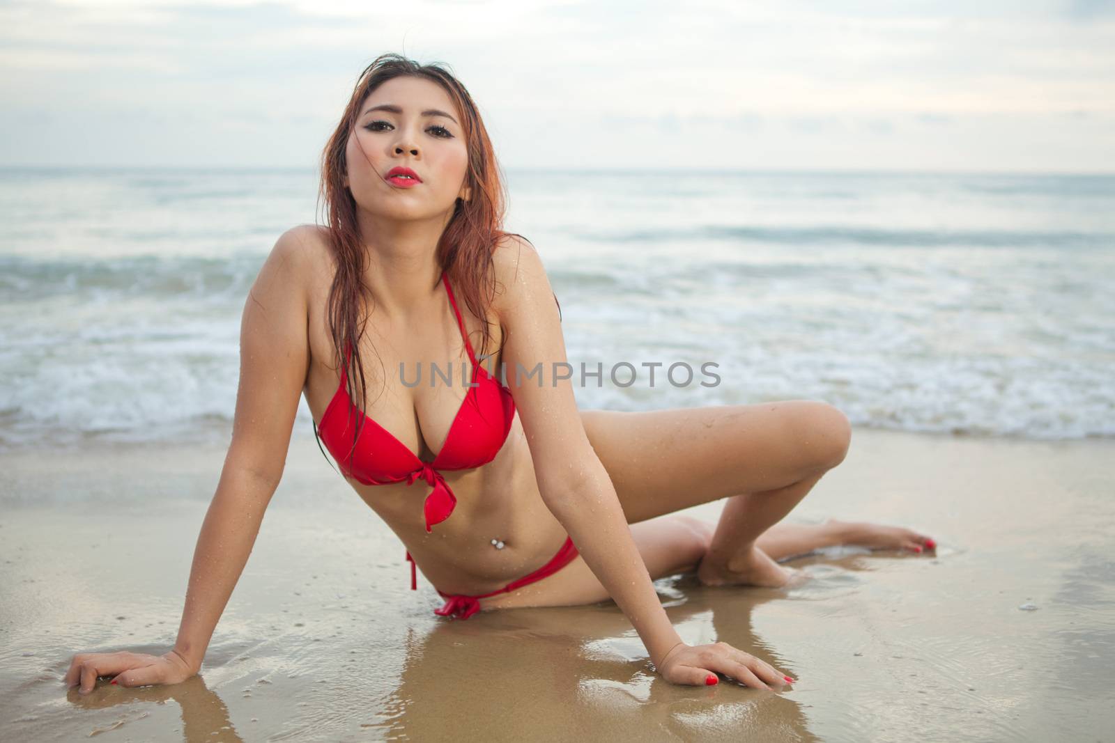 Beautiful asian woman in red bikini posing at beach