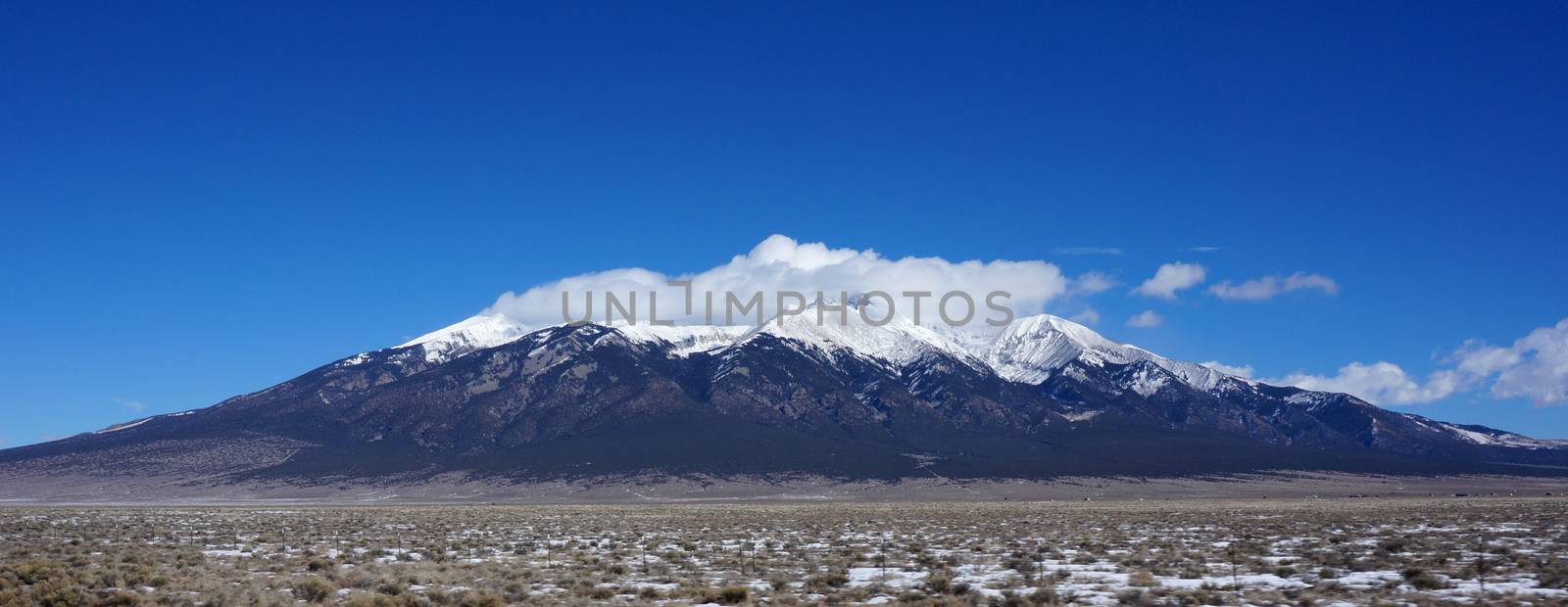 View of mountains in Colorado in winter time. Top of the mountain is being covered by the white snow.
