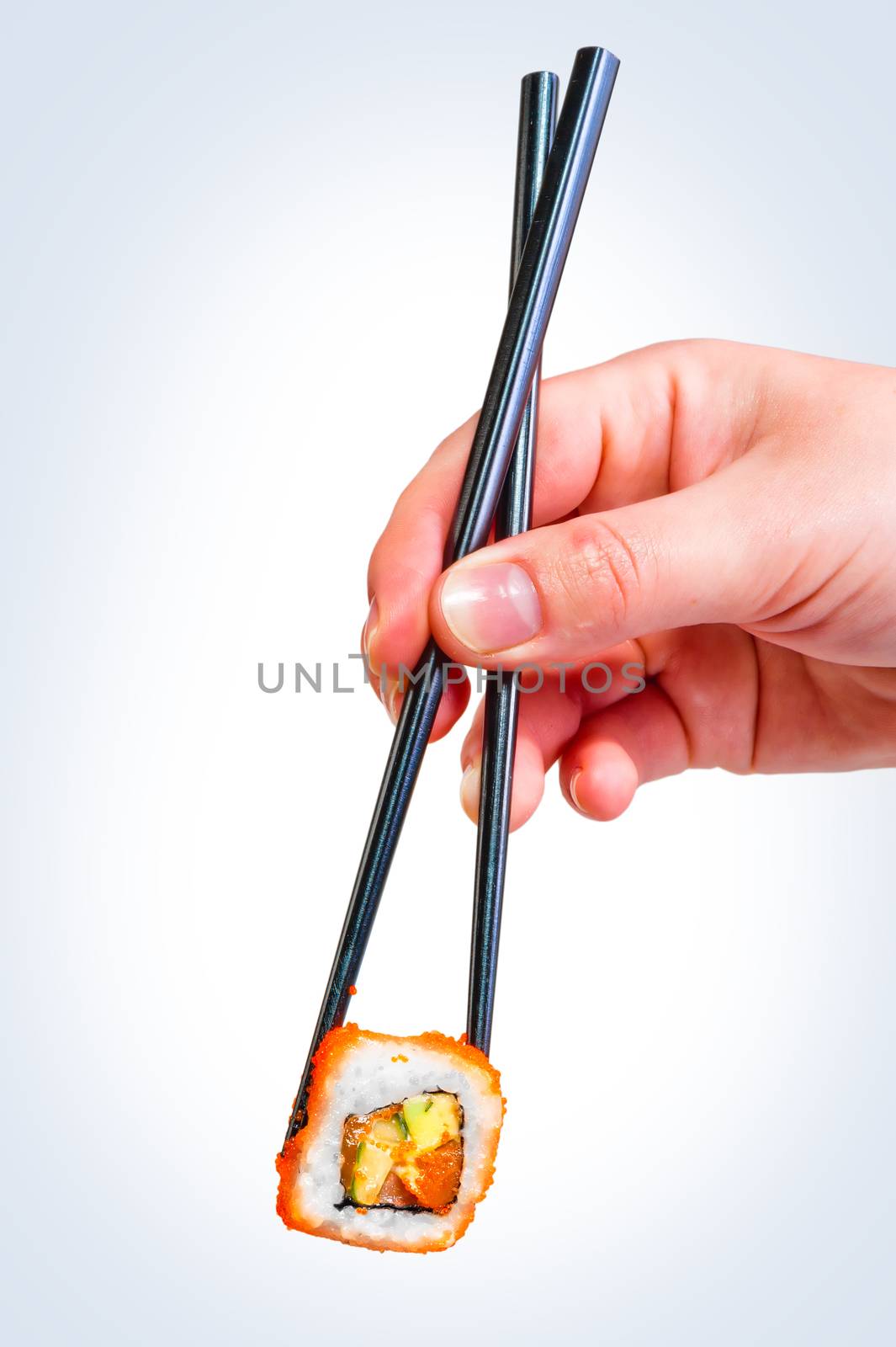 female hand holding chopsticks Japanese roll