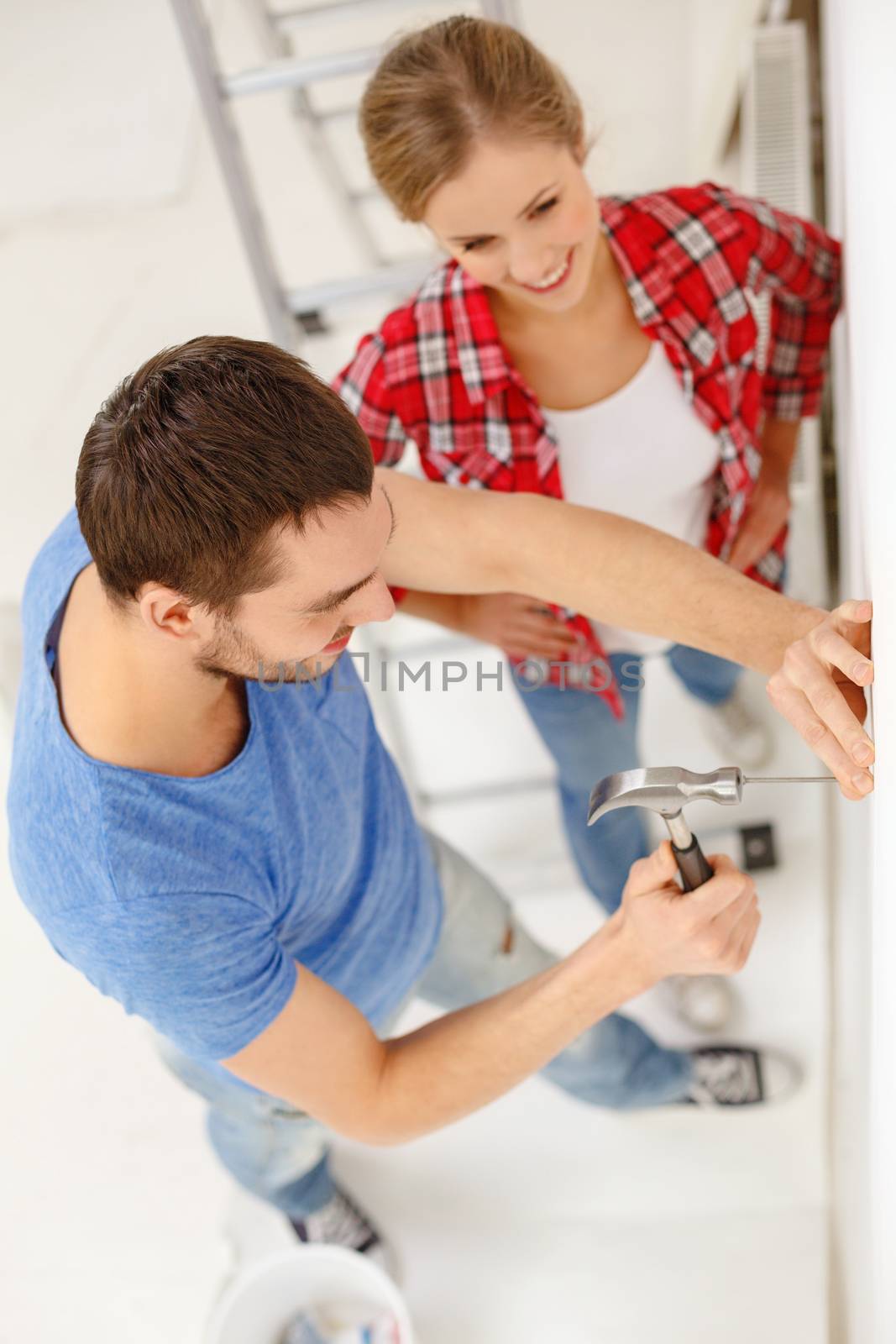 repair, building and home concept - smiling couple renovating new home