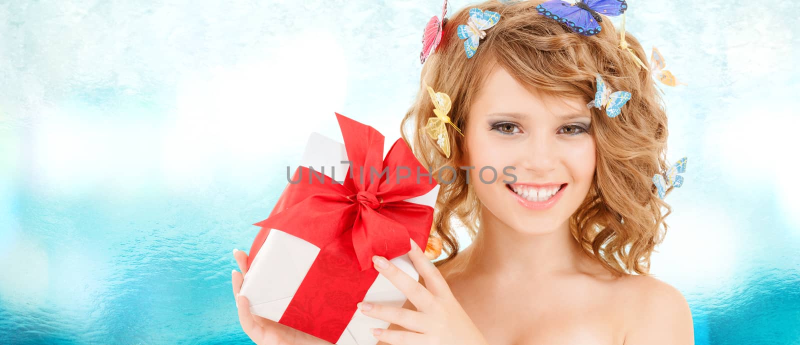 health, holidays and beauty concept - happy teenage girl with butterflies in hair showing gift box