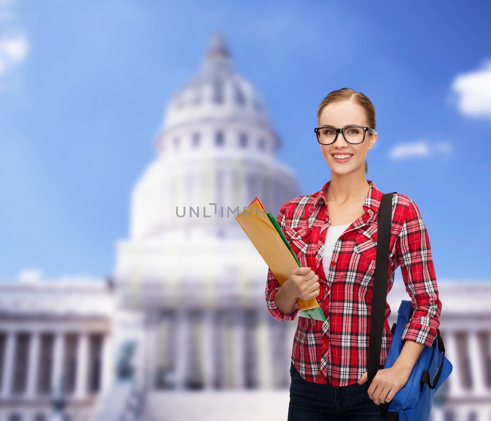 education and people concept - female student in eyeglasses with bag and folders