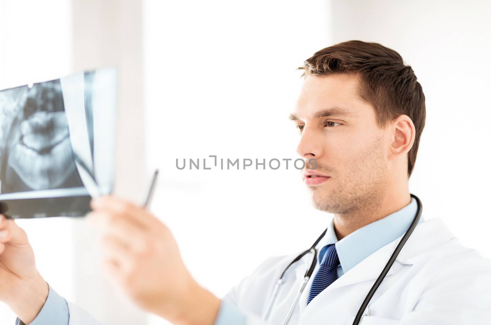 male doctor or dentist looking at x-ray by dolgachov