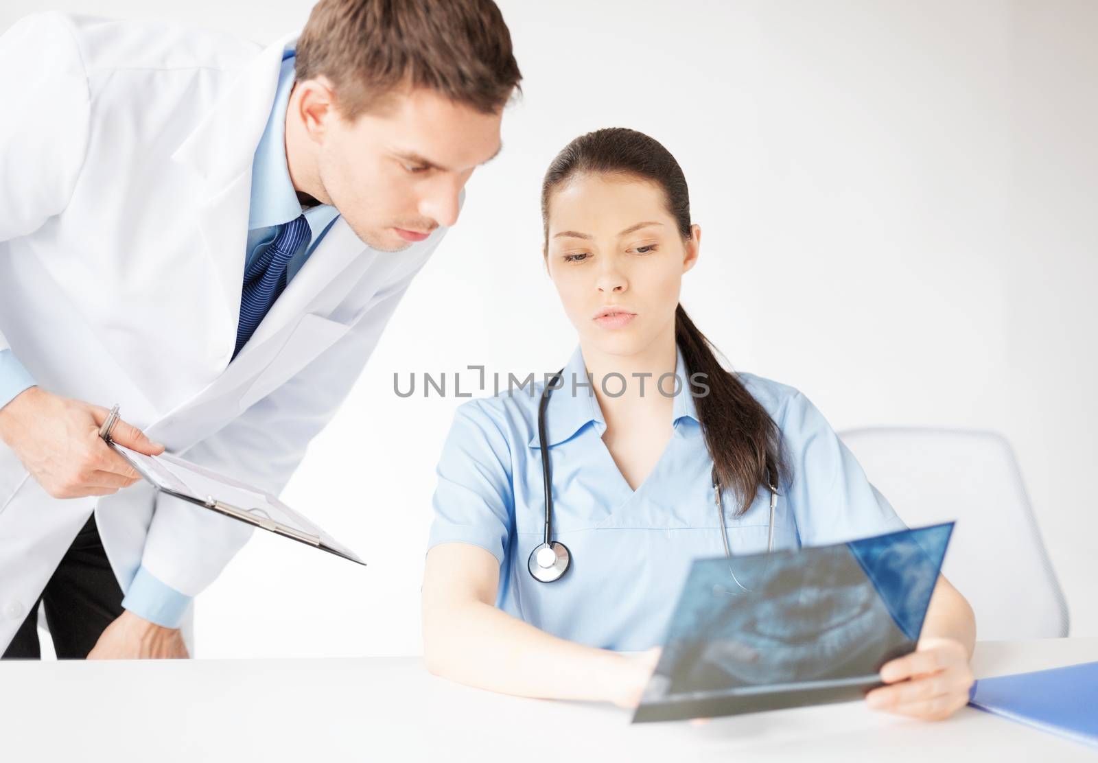 two medical workers looking at x-ray by dolgachov
