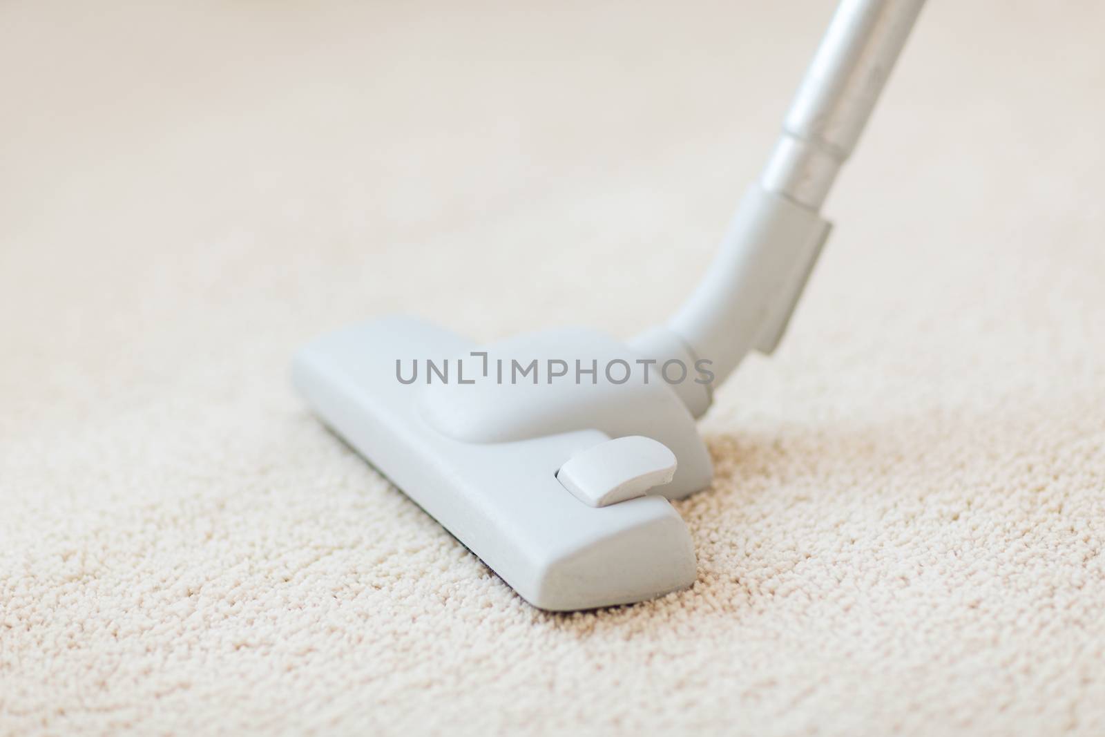 cleaning and home concept - close up of male hoovering carpet