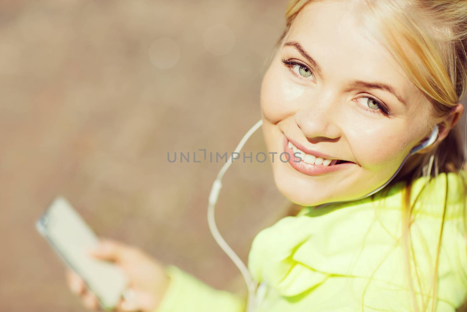 fitness and lifestyle concept - woman doing sports and listening to music outdoors