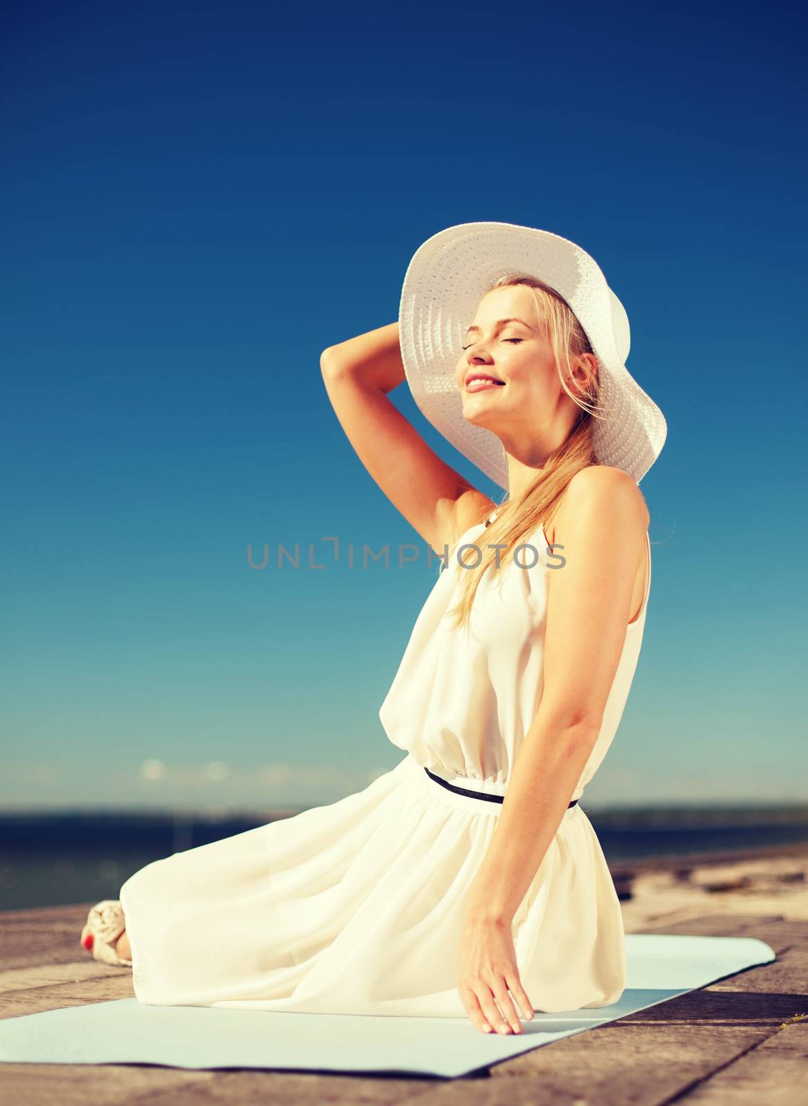 fashion and lifestyle concept - beautiful woman in hat enjoying summer outdoors