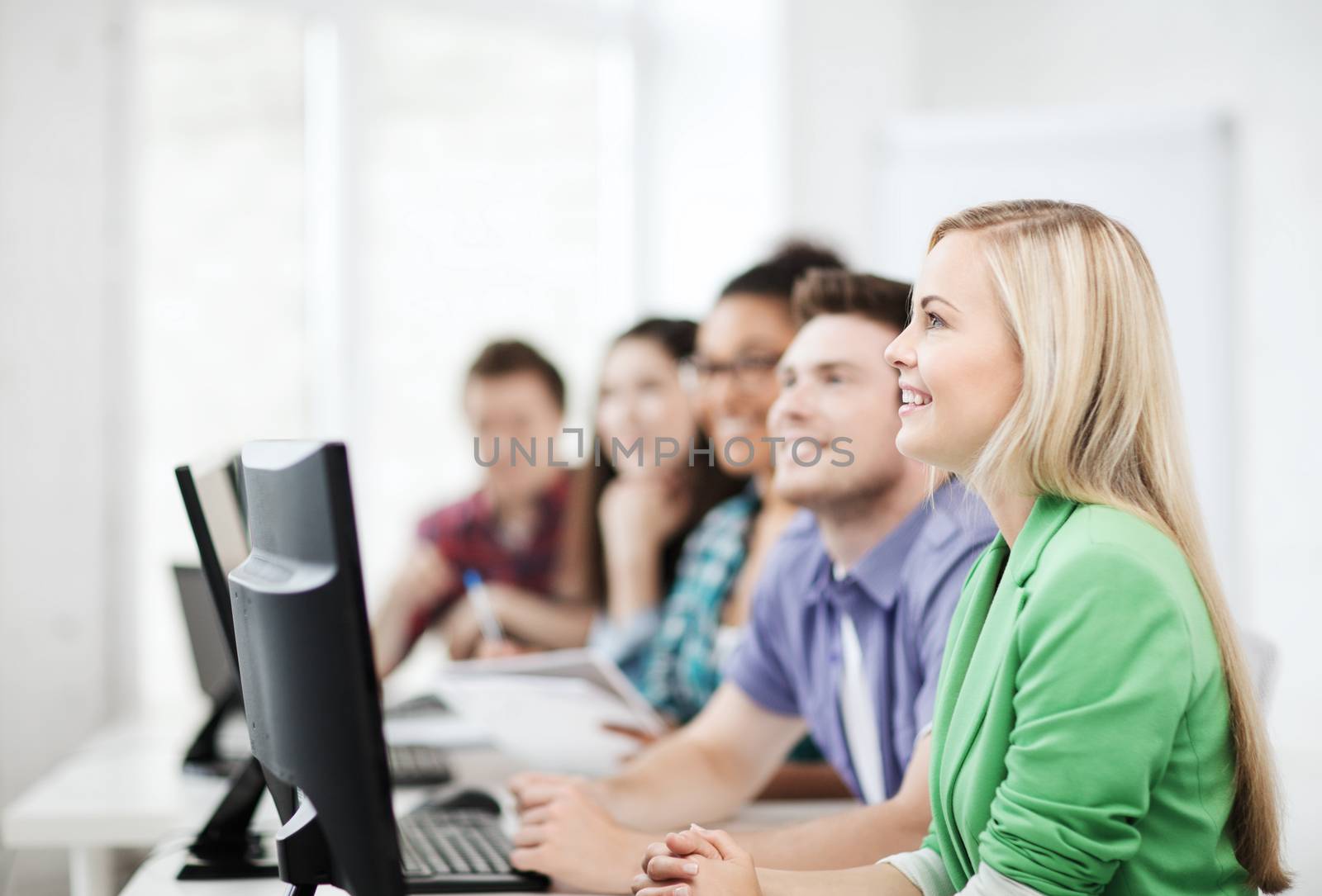 education concept - students with computers studying at school