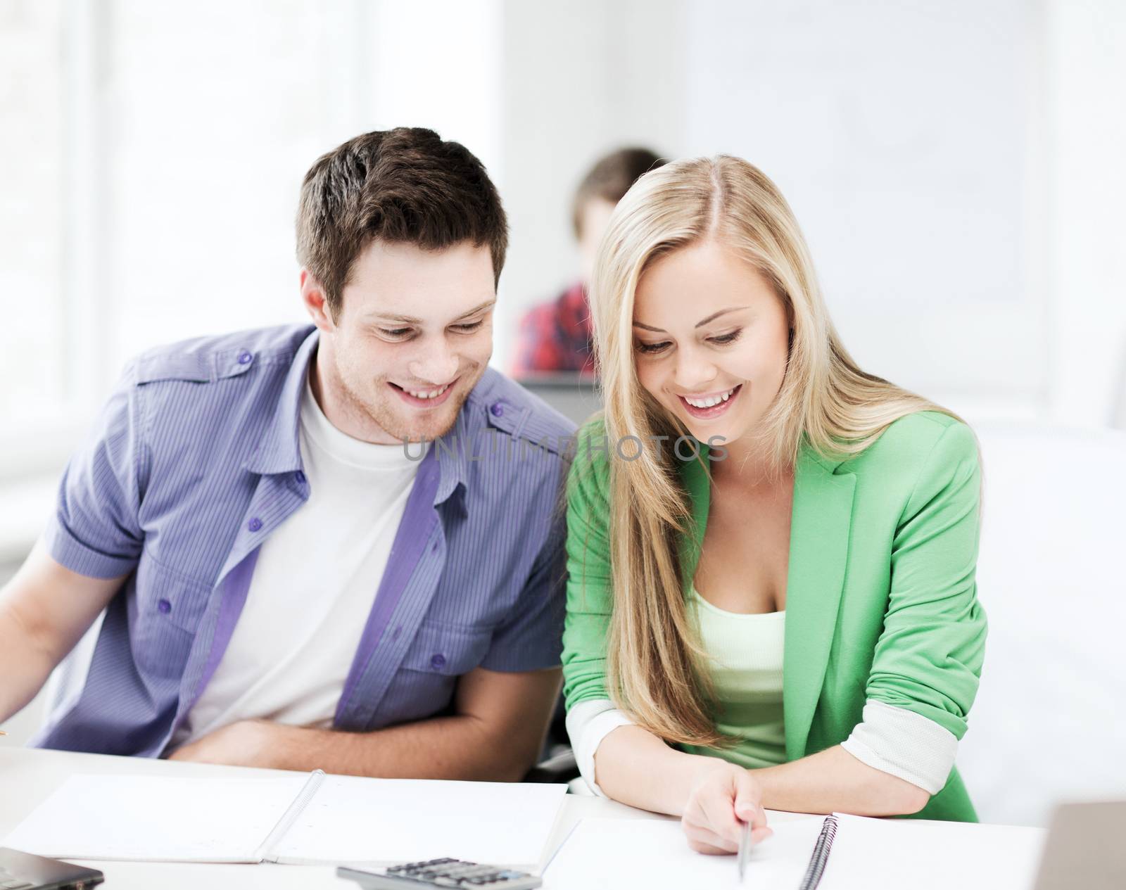 education concept - smiling students doing mathematics at school