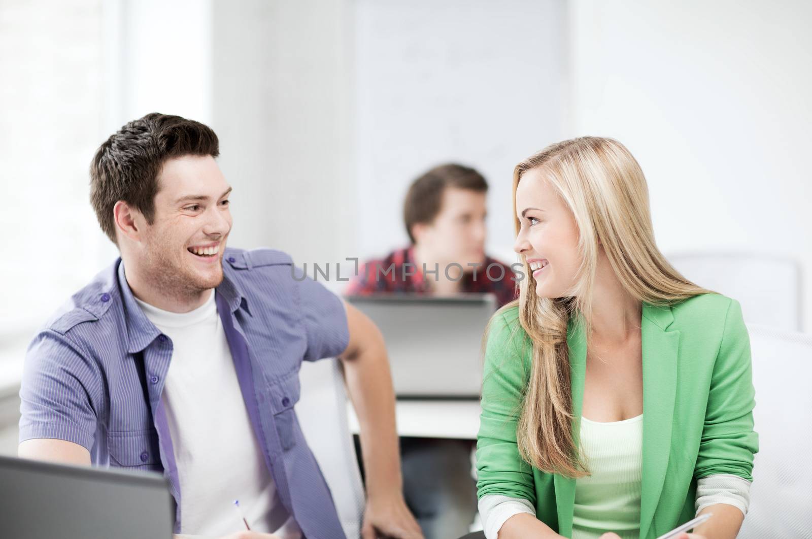 education concept - picture of smiling students looking at each other at school