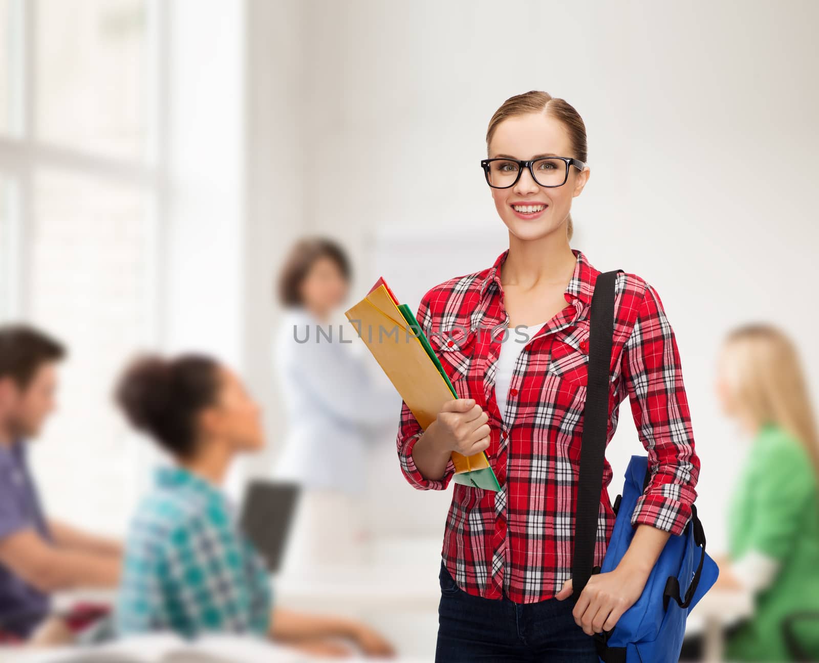 education and people concept - female student in eyeglasses with bag and folders