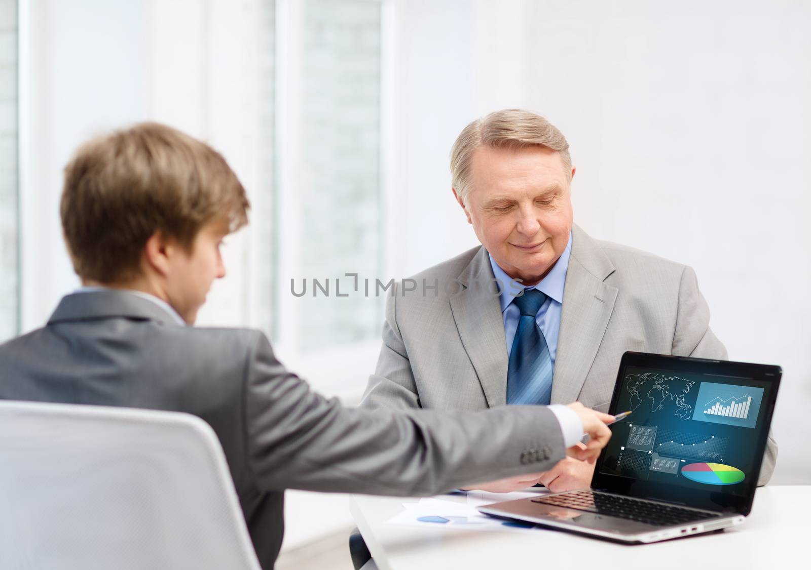 older man and young man with laptop computer by dolgachov