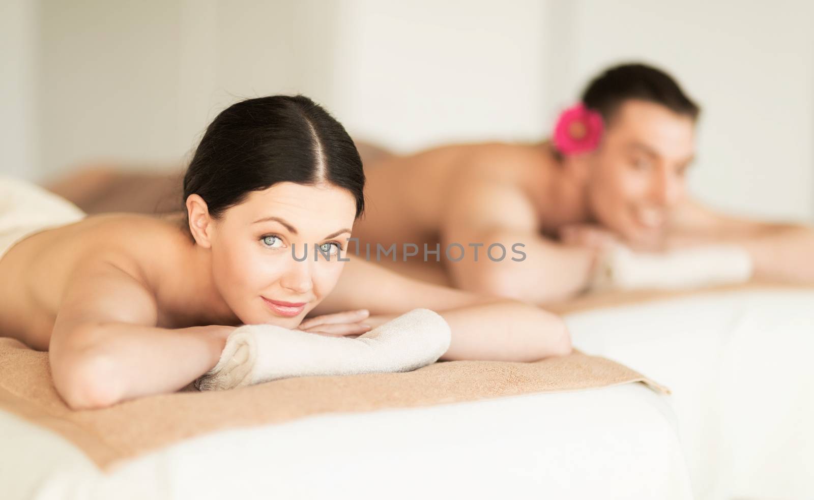 healthcare and beauty concept - picture of couple in spa salon lying on the massage desks