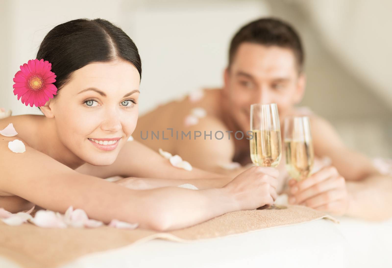 healthcare and beauty concept - picture of couple in spa salon drinking champagne