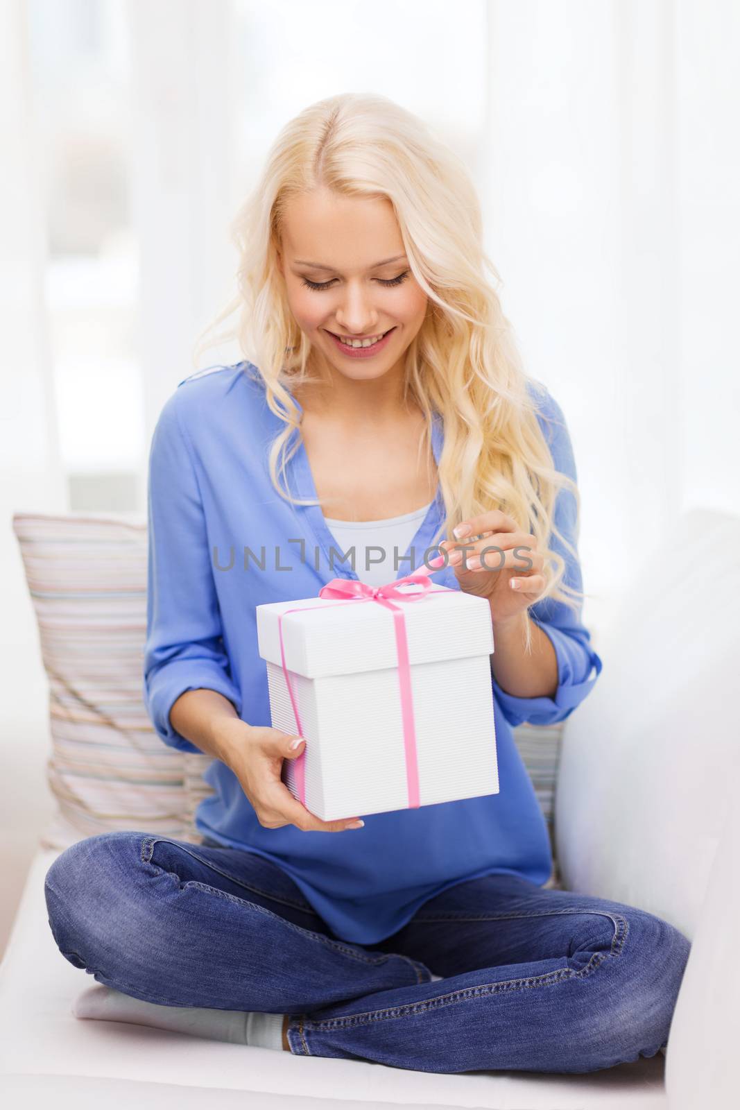 smiling woman with gift box at home by dolgachov