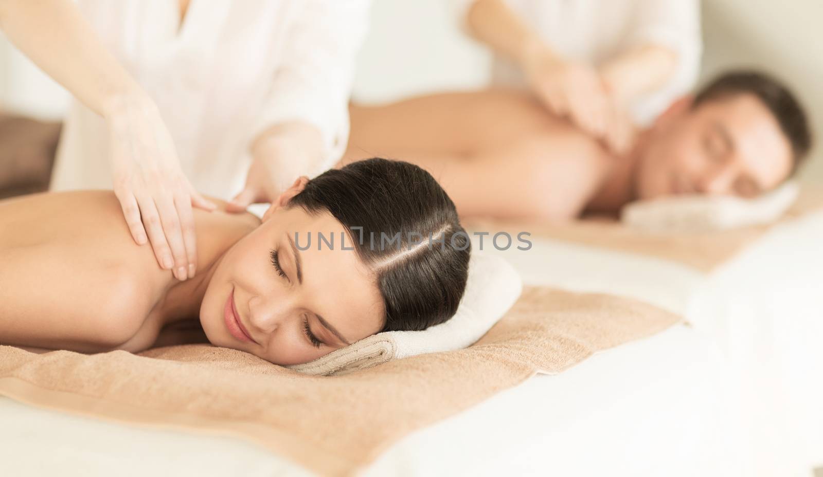 healthcare and beauty concept - picture of couple in spa salon getting massage