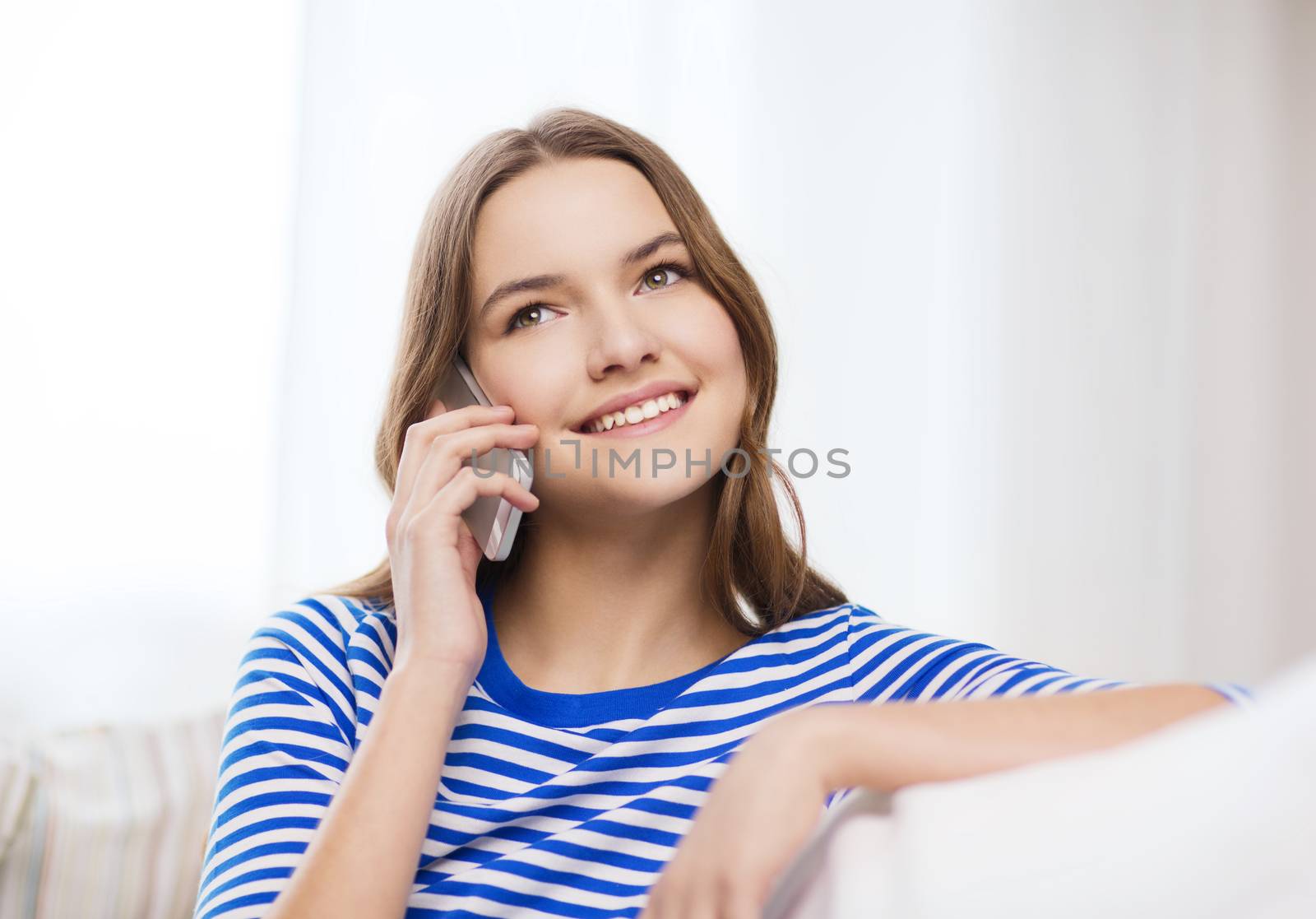 smiling teenage girl with smartphone at home by dolgachov