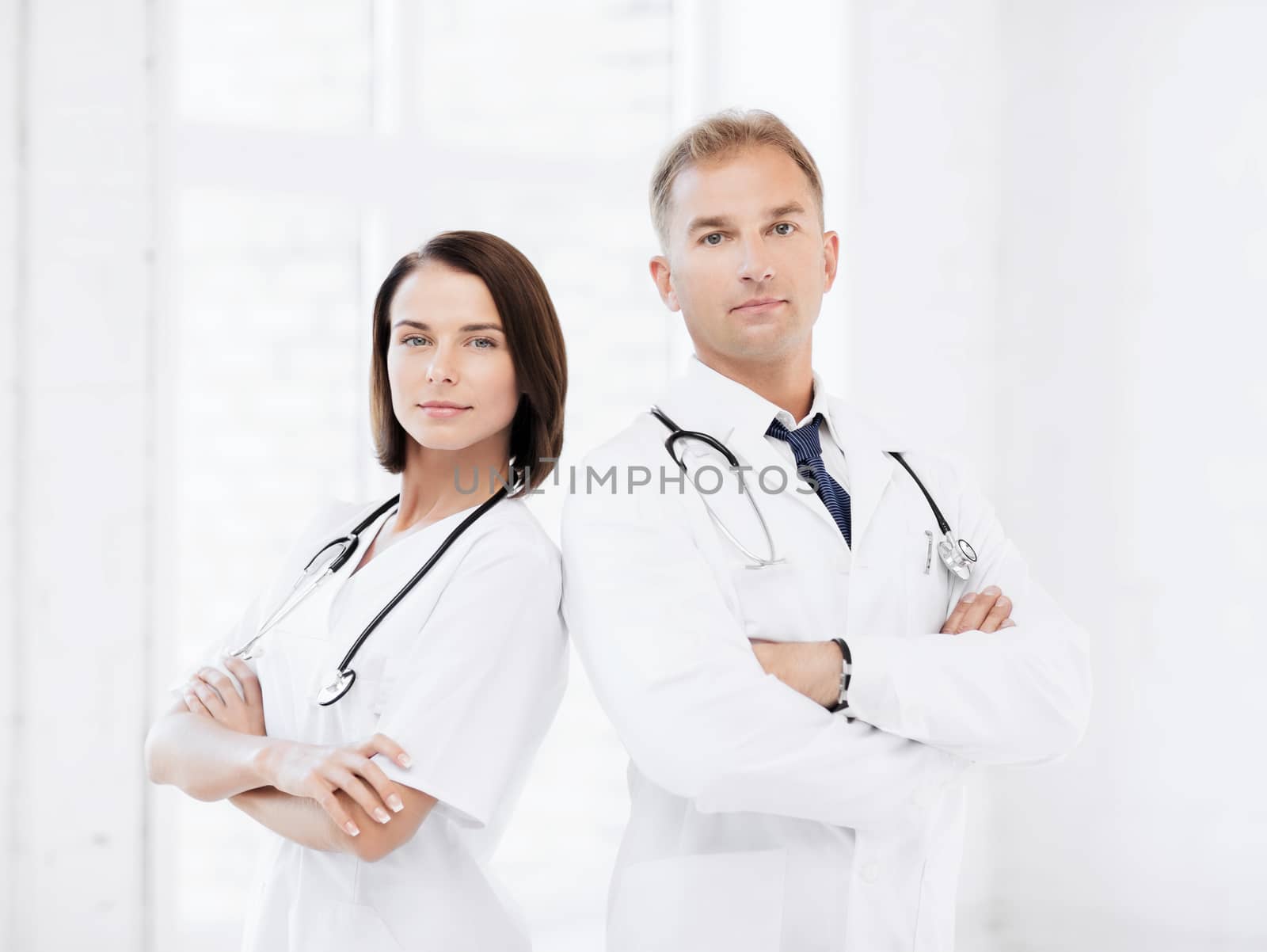 two doctors with stethoscopes by dolgachov