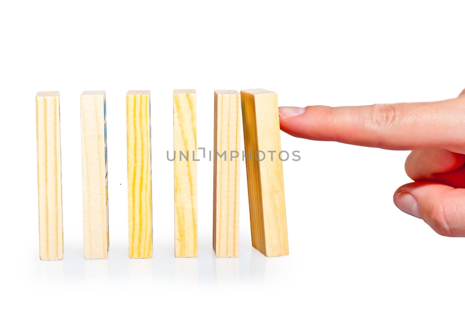 female hand pushing a row of dominoes lined up by kosmsos111