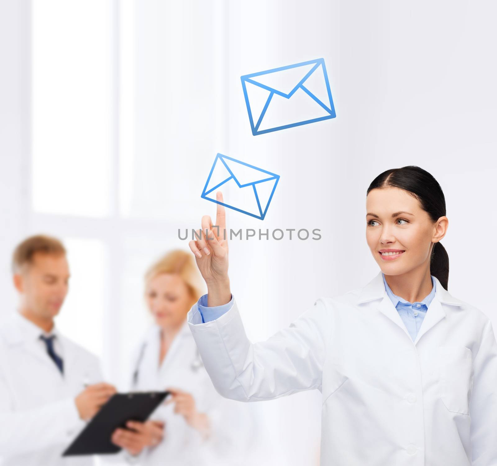 healthcare, medicine and technology concept - smiling female doctor pointing to envelope