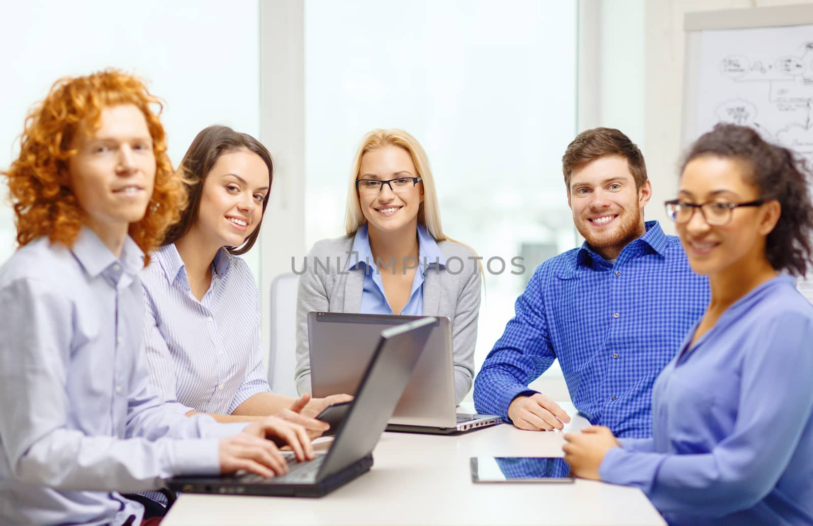 smiling team with laptop and table pc computers by dolgachov