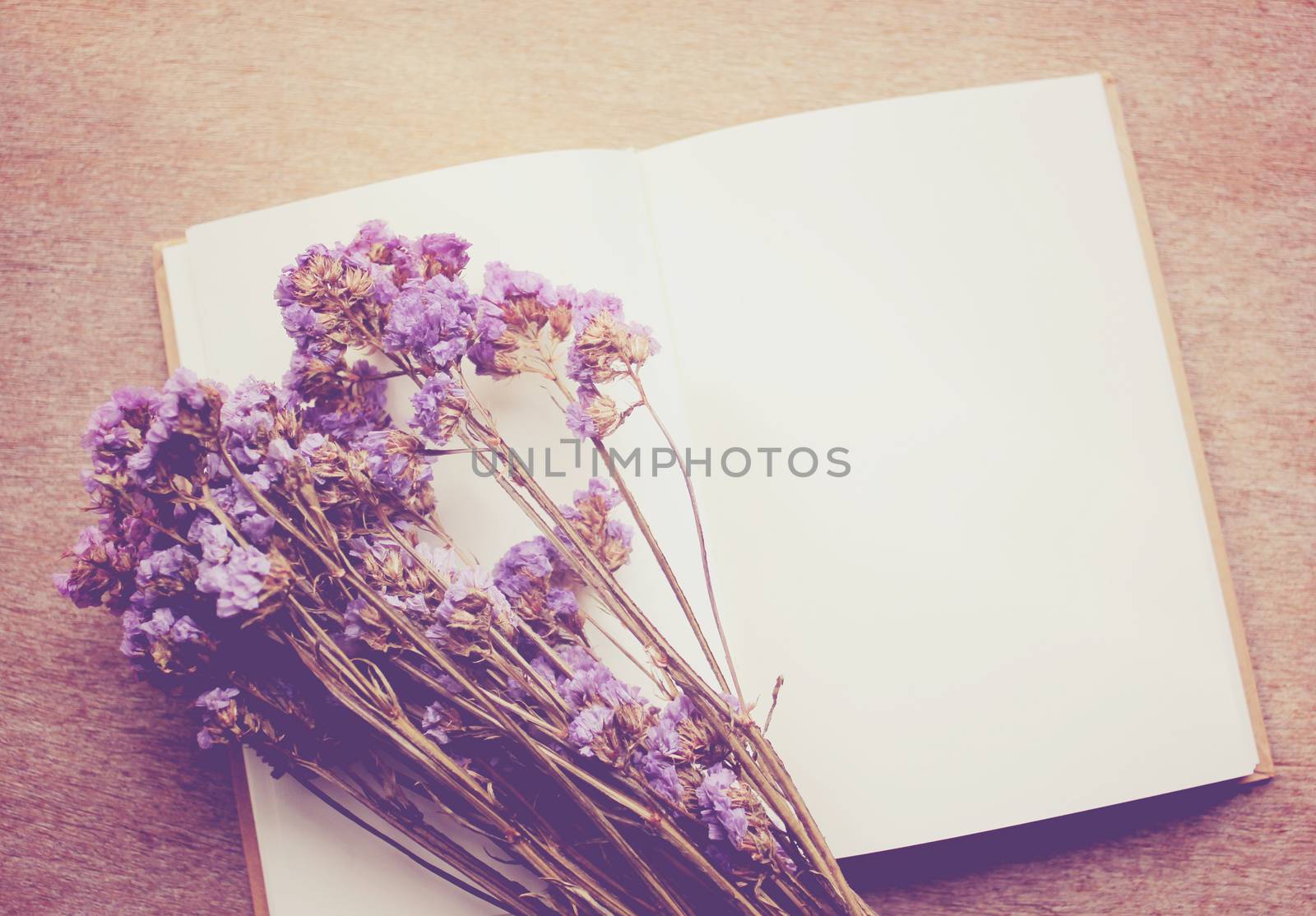 Blank notebook and dried statice flowers with retro filter effect