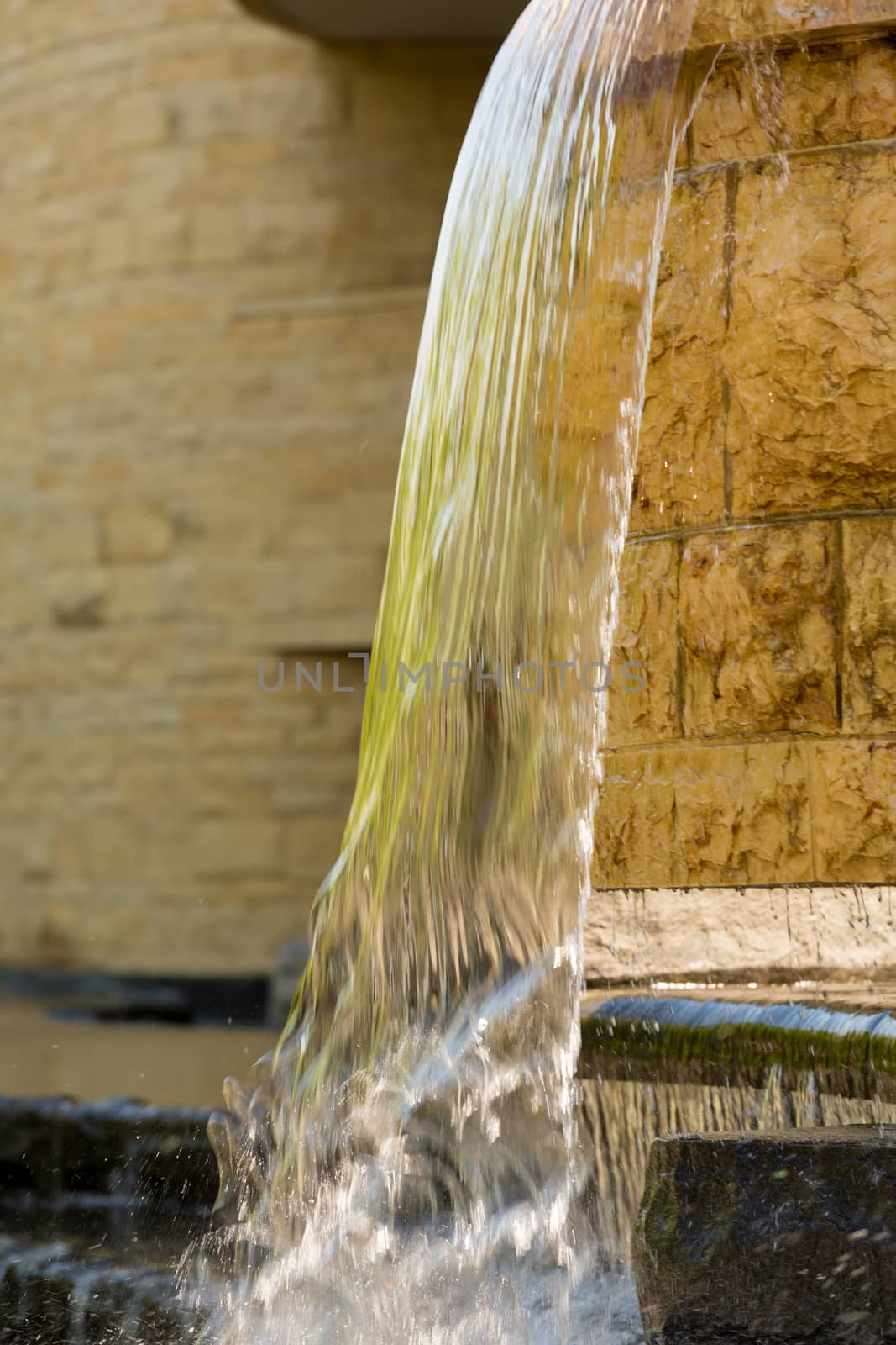 Waterfall reflects the green of surrounding trees as part of the garden around the Museum of the American Indian in Washington DC