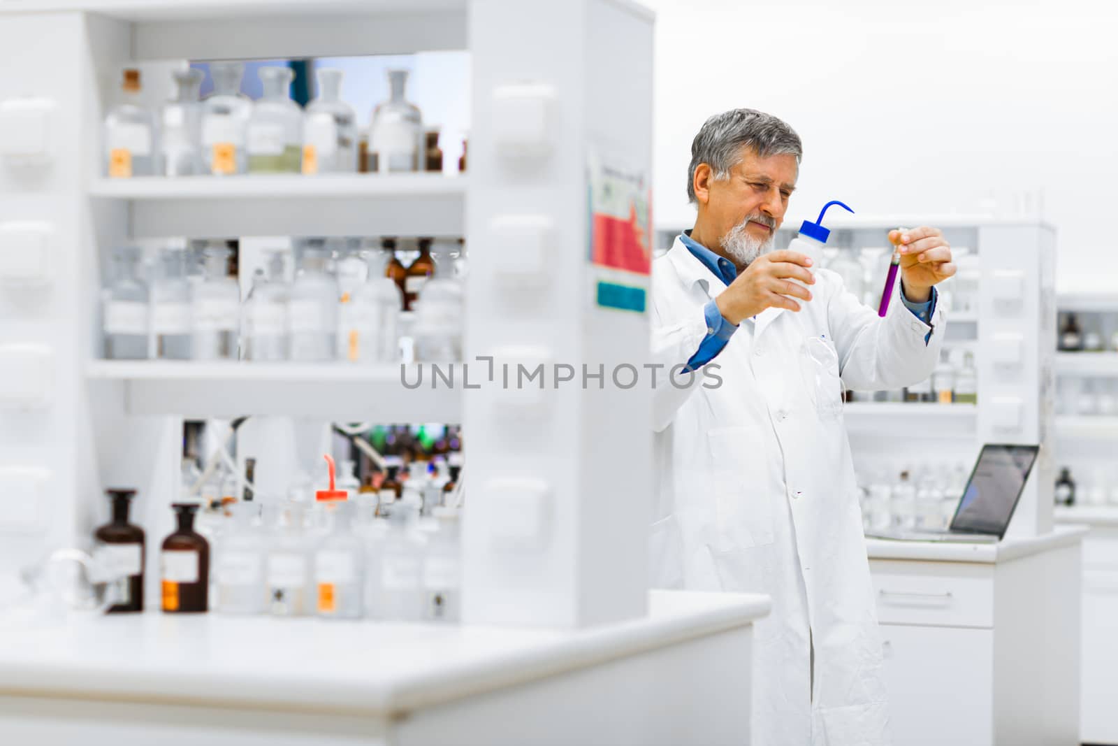 Senior male researcher carrying out scientific research in a lab (shallow DOF; color toned image)