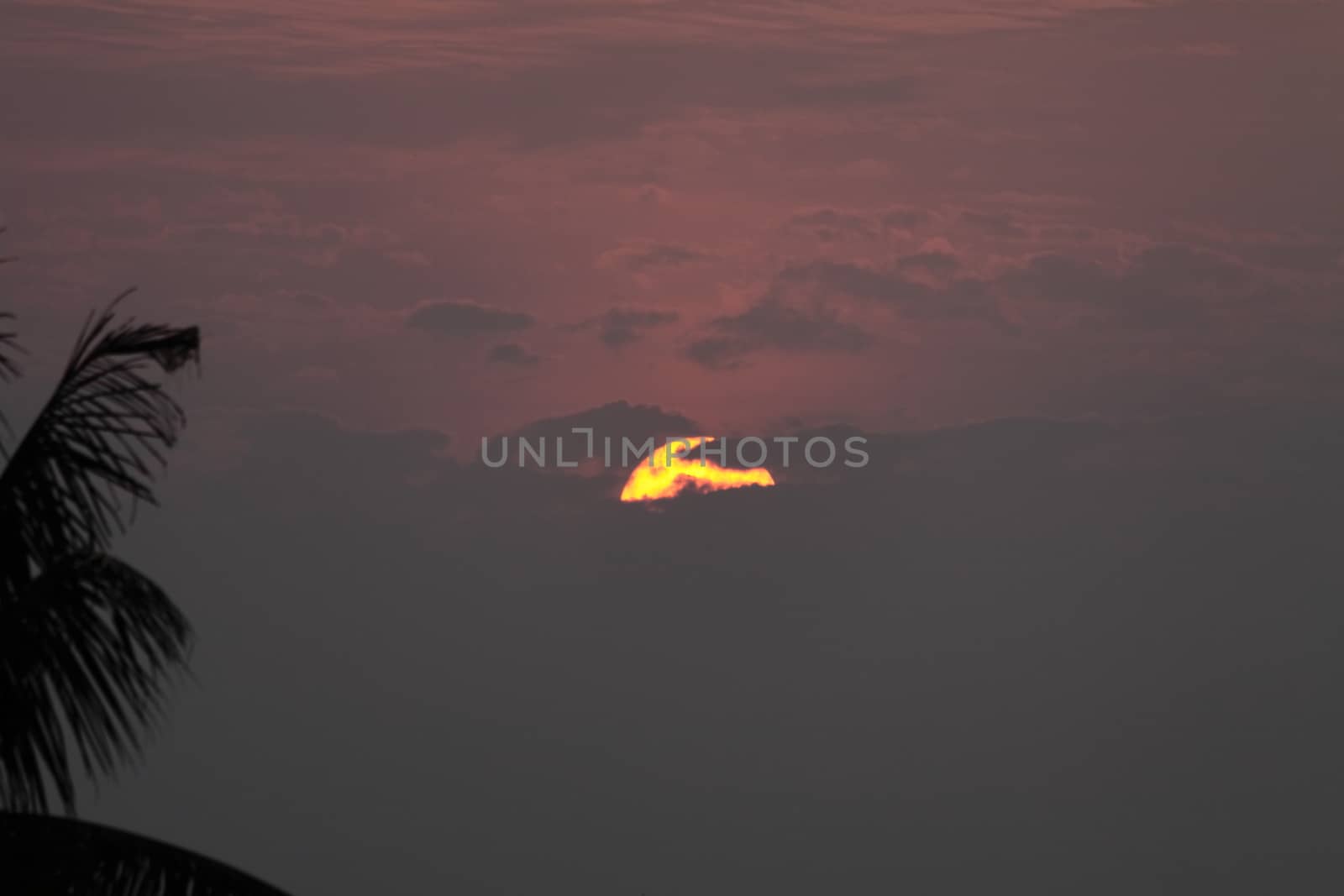 Orange  Sun hidden by  clouds dramatic sunset by giddavr