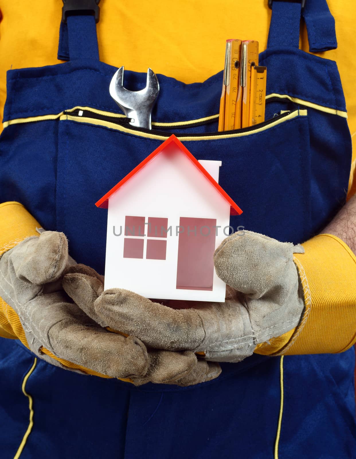 Worker holding house model in hand. Real property or insurance concept 