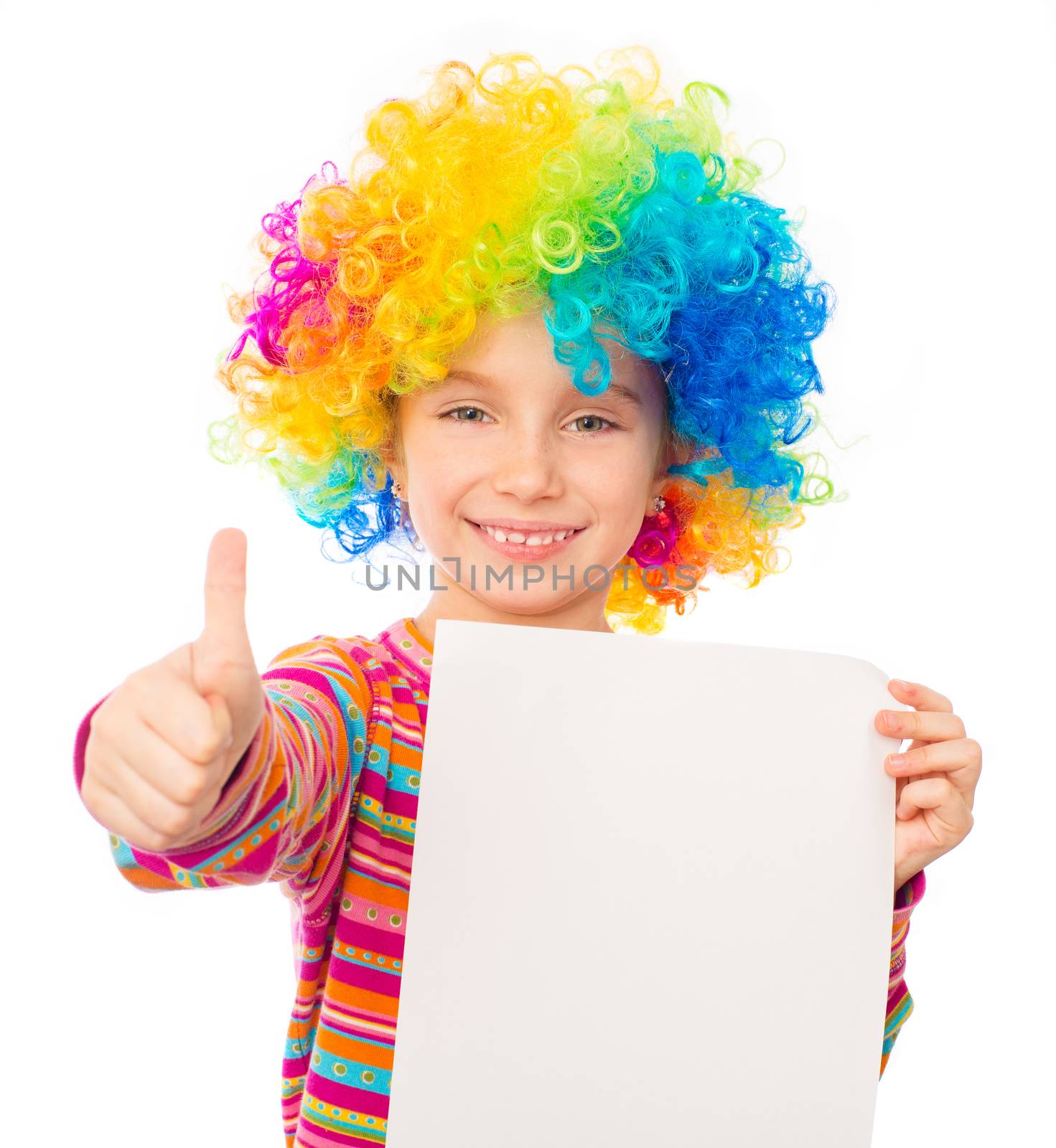 smiling little girl in clown wig with white blank and thumbs up isolated on white background