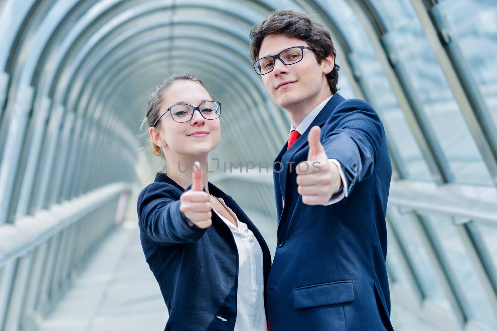 expressive portrait of junior executives of company thumb up by pixinoo