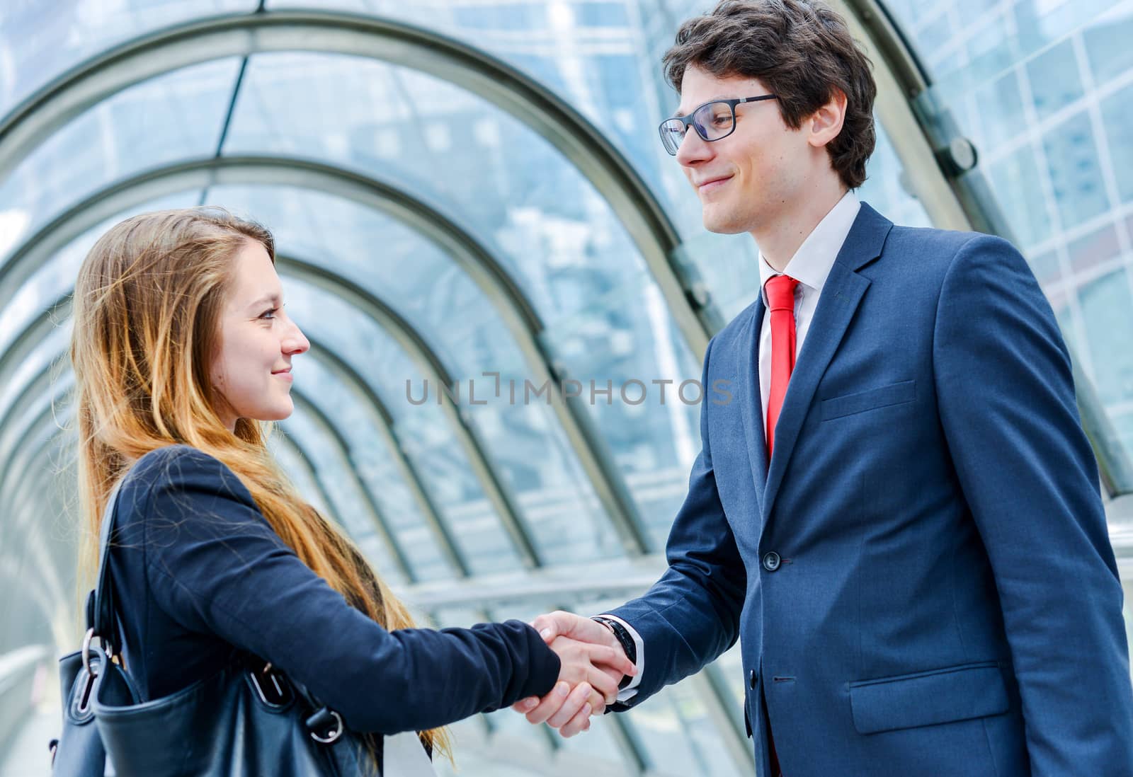 Junior executives dynamics shaking hands by pixinoo