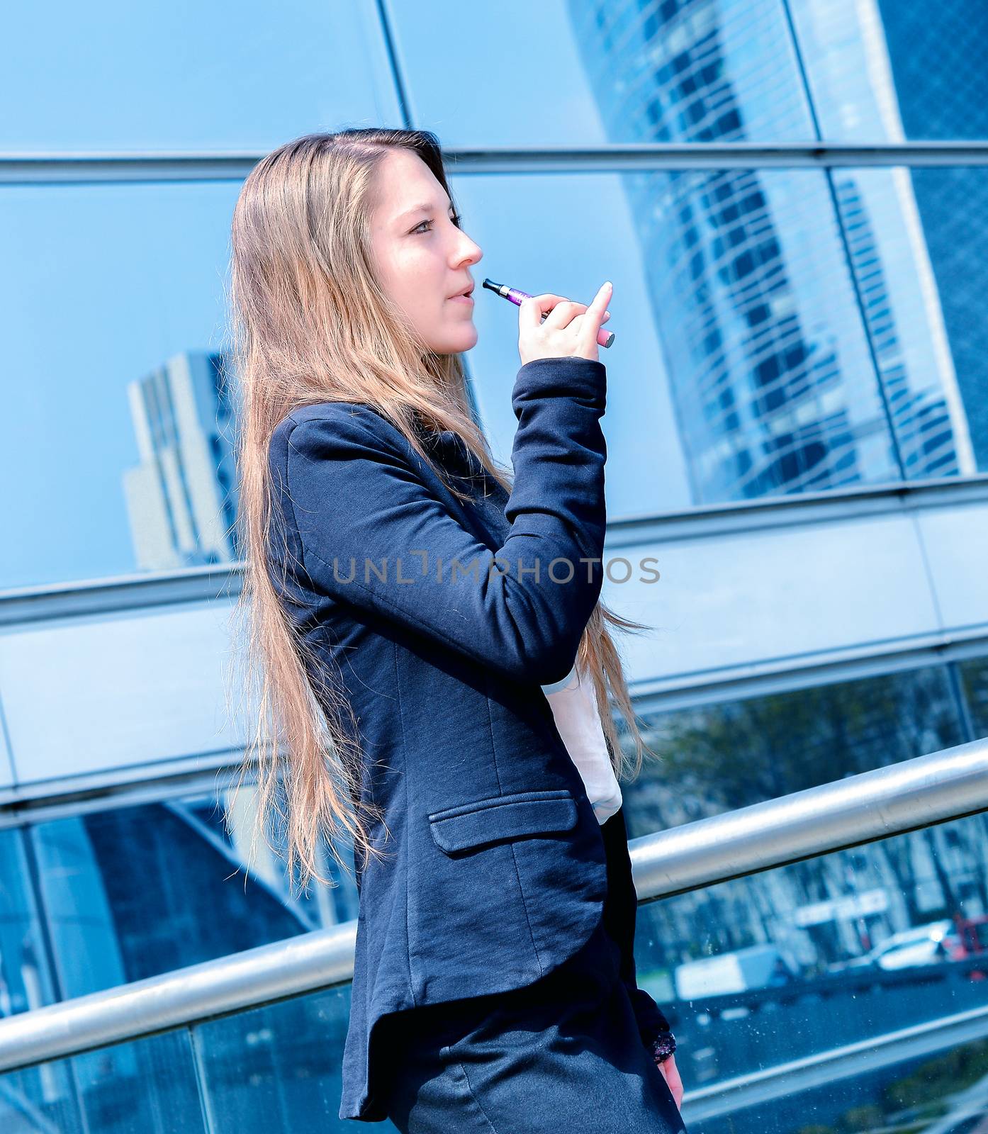 Nice portrait of young worker during coffee break with an electronic cigarette