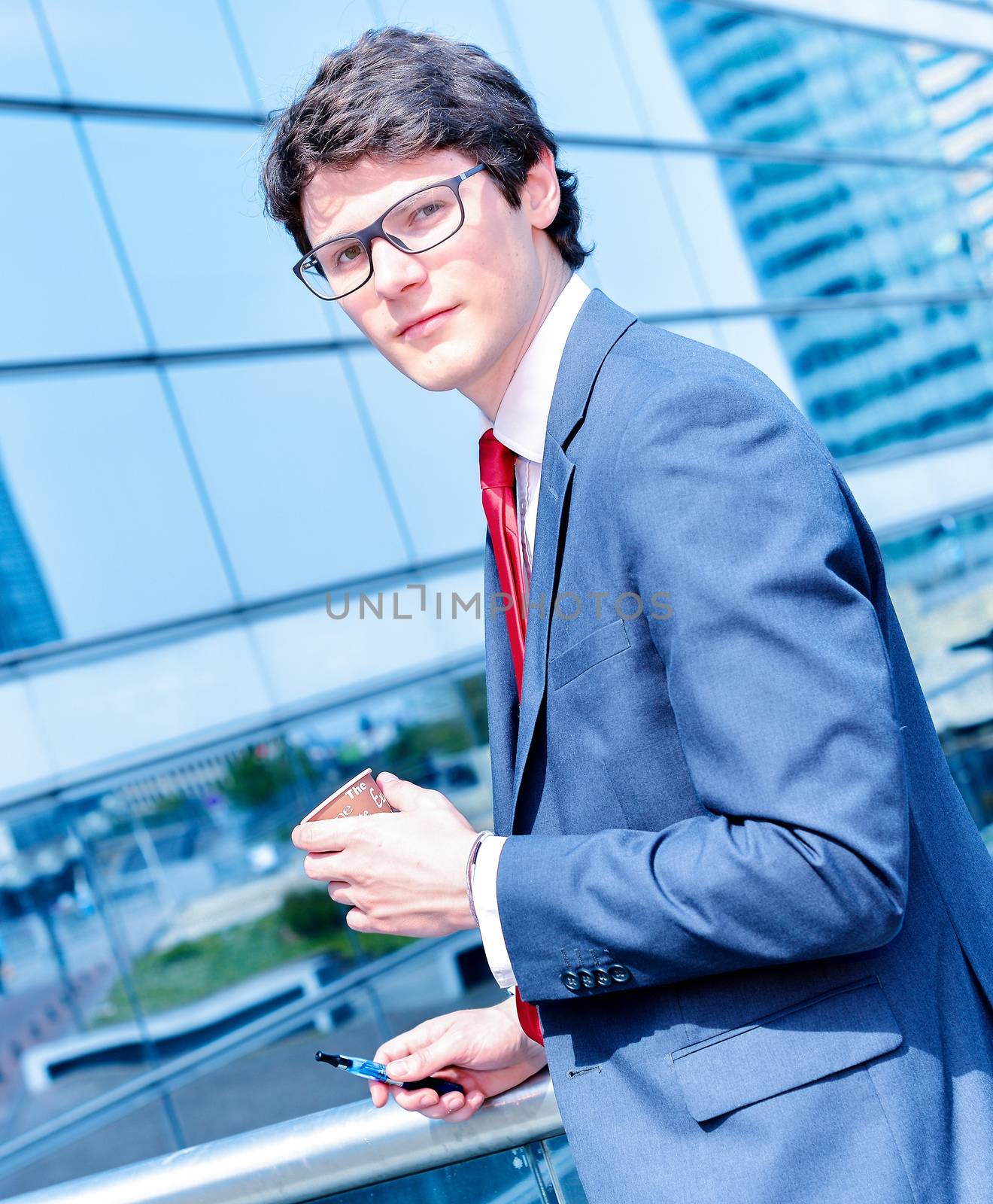 Nice portrait of young worker during coffee break with an electronic cigarette