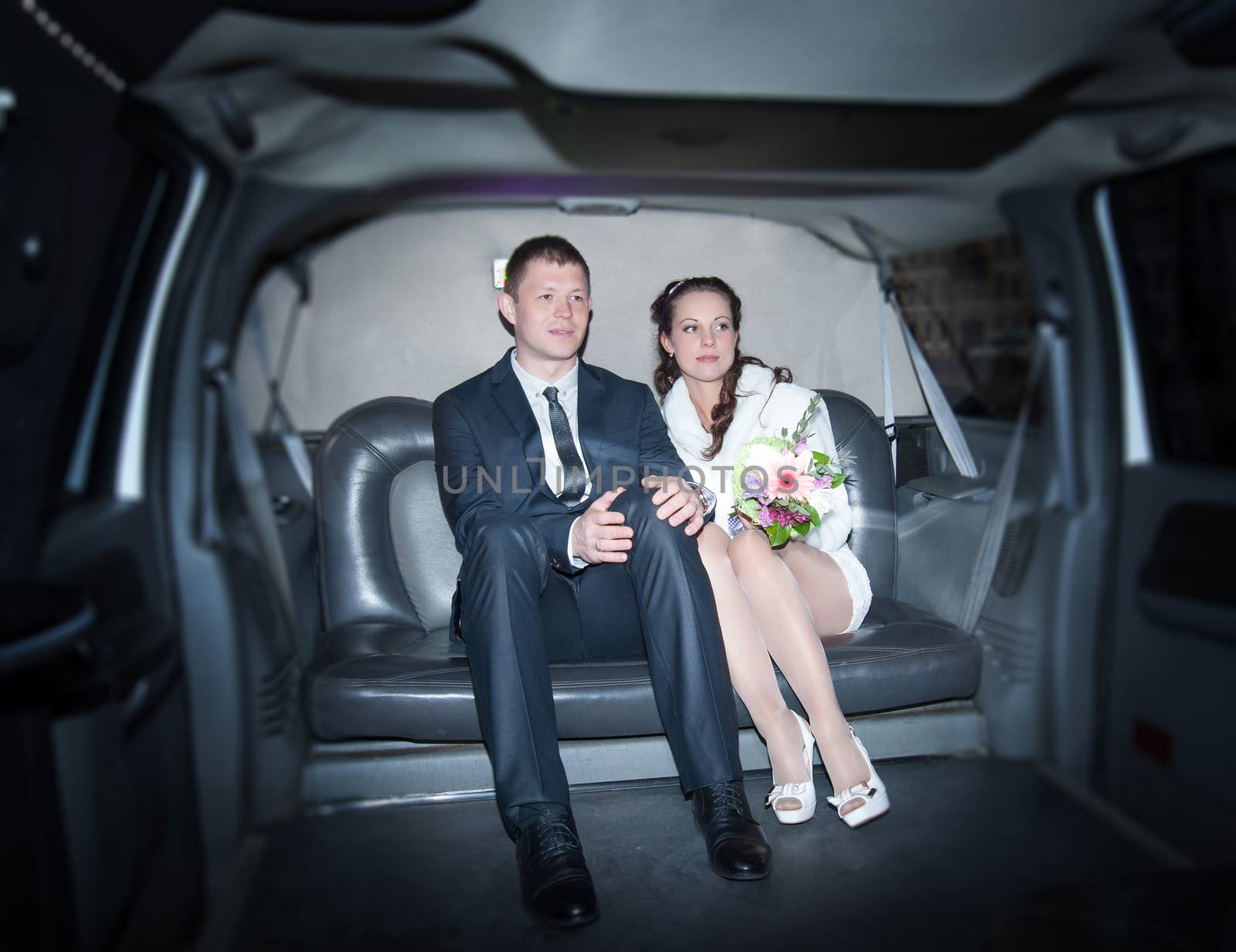 two loving people are sitting in a limousine wedding day