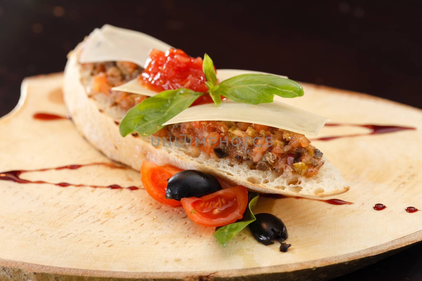 Italian appetizer bruschetta with tomato, basil and black olives  by shebeko