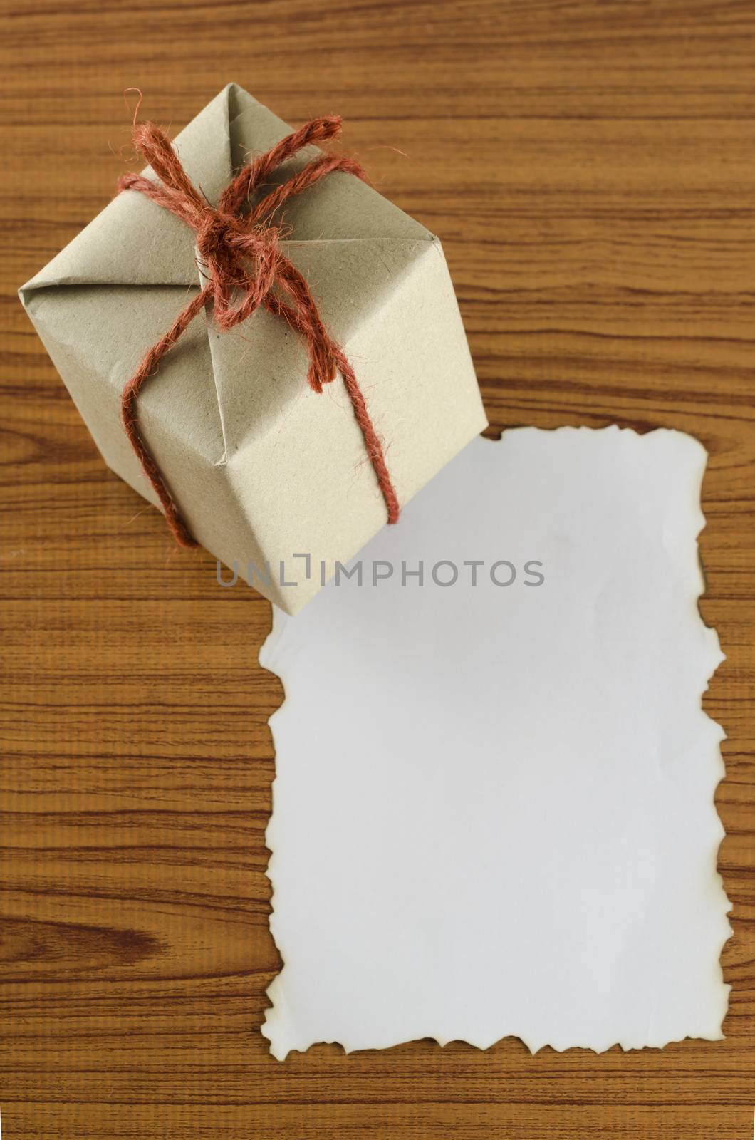 gift box with paper write your note on wood background