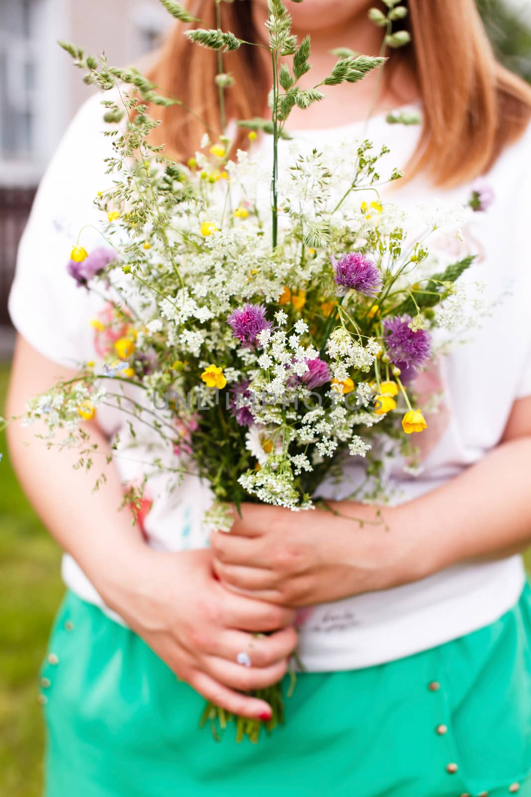 Woman holding wild flowers by shebeko