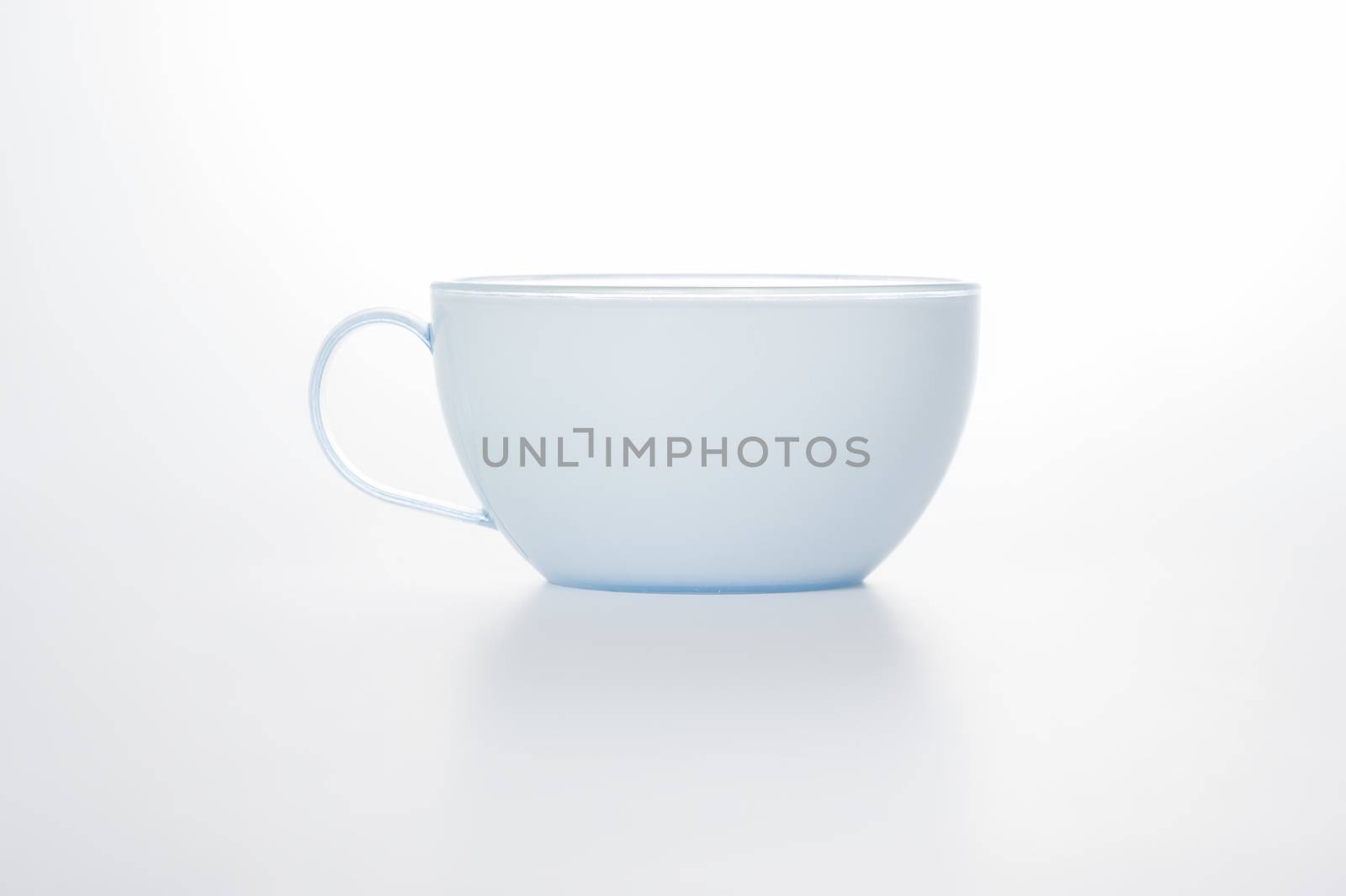 Studio shot on a white background of a stylish modern plain white cup with a handle for serving hot beverages such as coffee and tea, with copyspace